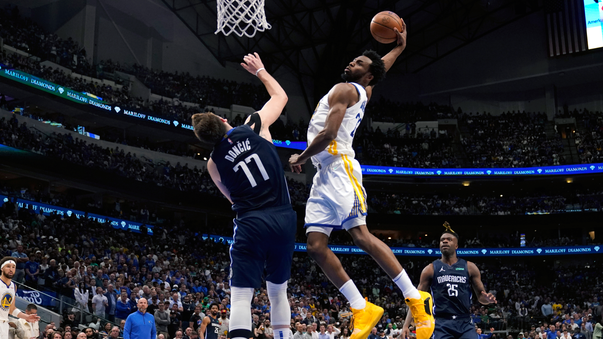 Golden State Warriors forward Andrew Wiggins (22) dunks the ball over Dallas Mavericks guard Luka Doncic (77) during the second half of Game 3 of the NBA basketball playoffs Western Conference Finals.