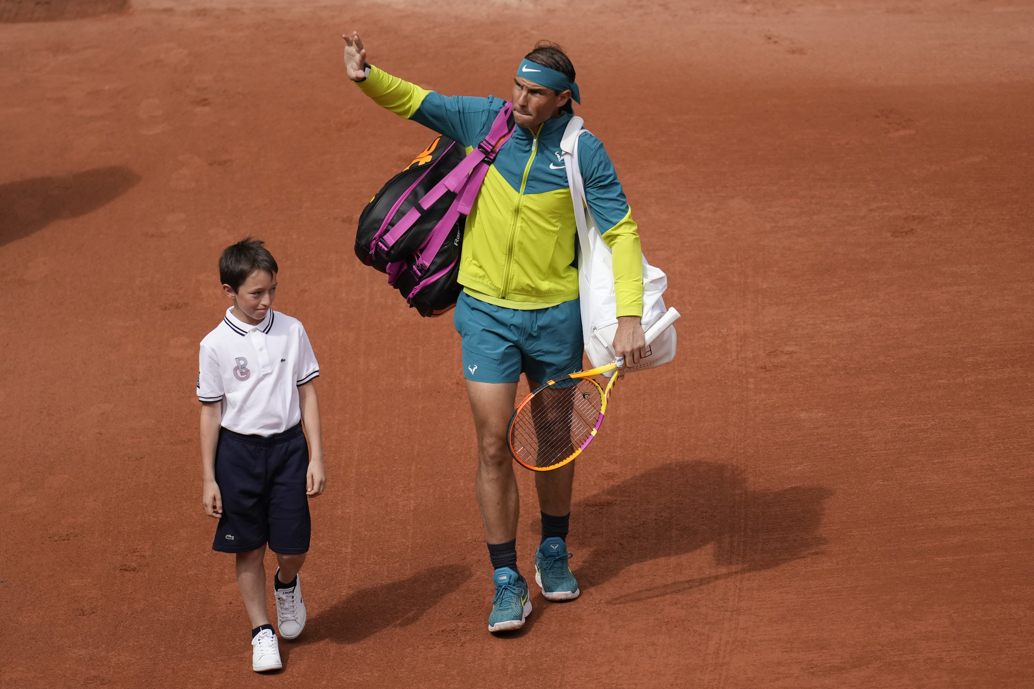 A boy accompanies Spain's Rafael  lt;HIT gt;Nadal lt;/HIT gt; as he enter center court for his first round match against Australia's Jordan Thompson at the French Open tennis tournament in Roland Garros stadium in Paris, France, Monday, May 23, 2022. (AP Photo/Christophe Ena)
