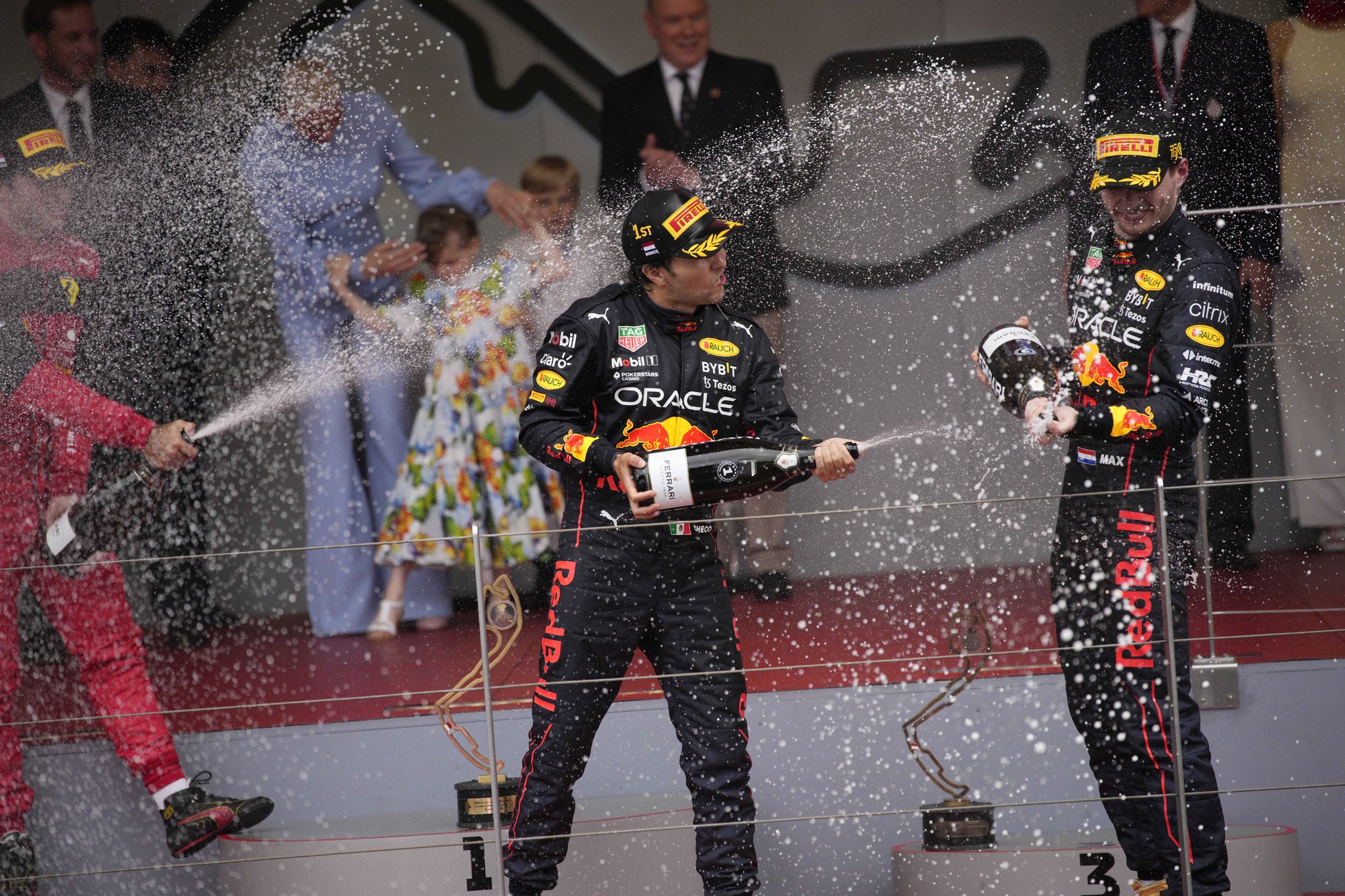 Winner Red Bull driver Sergio Perez of Mexico, center, sprays champagne to his teammate third placed Red Bull driver Max Verstappen and Ferrari driver Carlos lt;HIT gt;Sainz lt;/HIT gt; of Spain on the podium of the Monaco Formula One Grand Prix, at the Monaco racetrack, in Monaco, Sunday, May 29, 2022. (AP Photo/Daniel Cole)