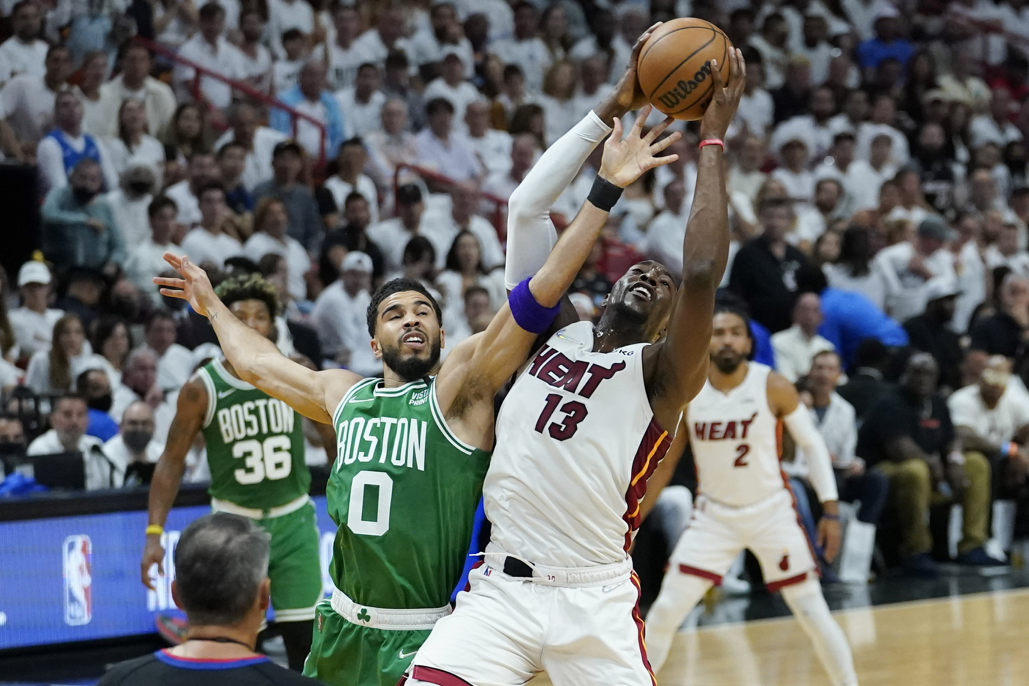 Miami Heat center Bam Adebayo (13) and Boston Celtics forward Jayson Tatum (0) go after a rebound.