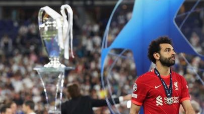 Salah, con gesto serio, y el trofeo de la Champions League al fondo.