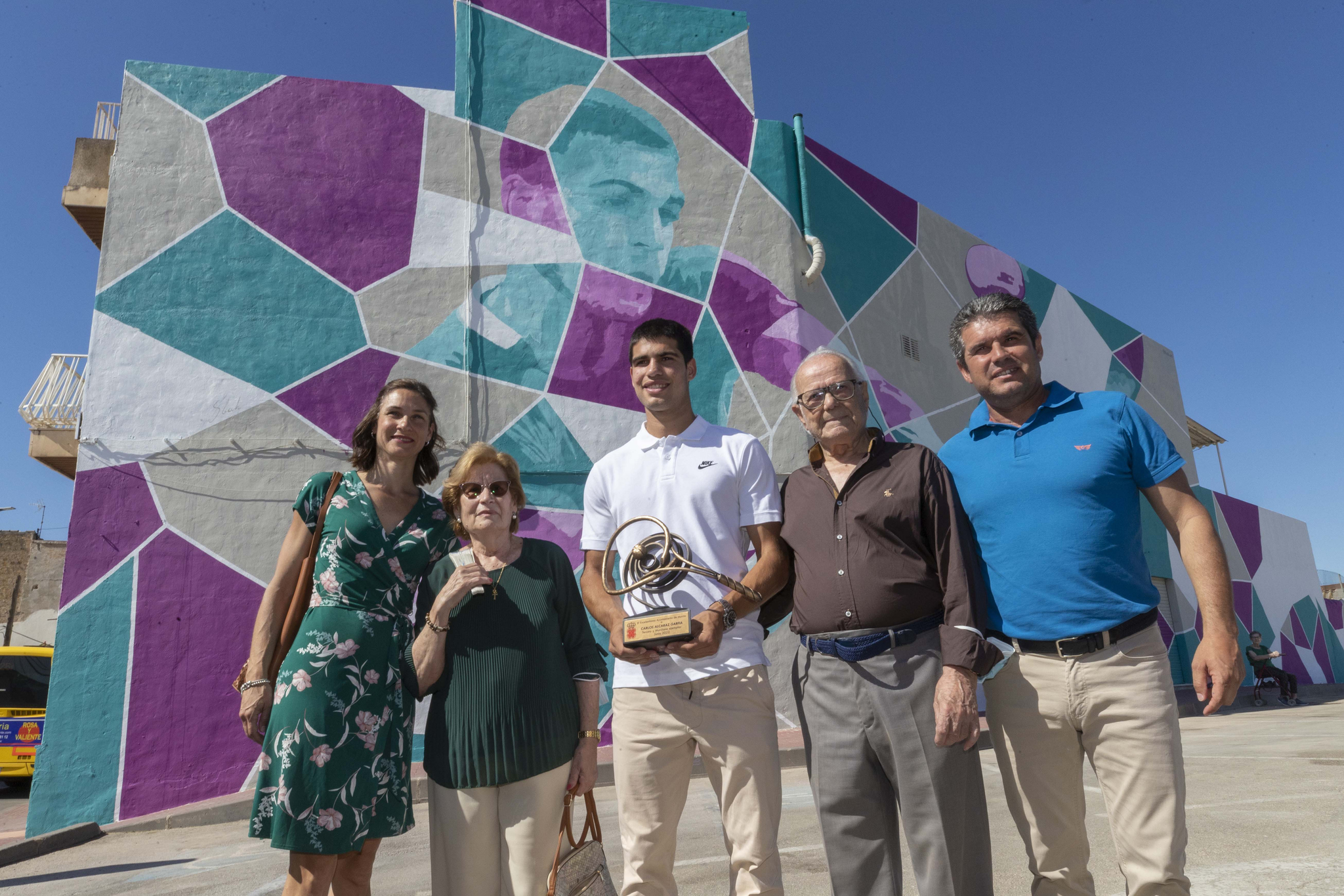 Carlos Alcaraz (c), acompañado de sus padres y de sus abuelos posan este lunes para la foto de familia junto al nuevo grafiti realizado en su honor.