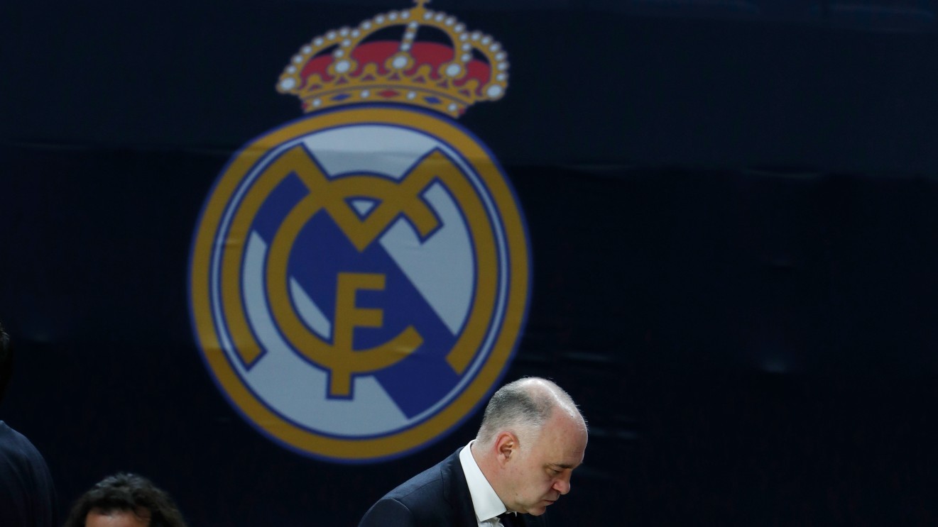 Pablo Laso, cabizbajo ante un escudo del Real Madrid, en un partido de 2021.