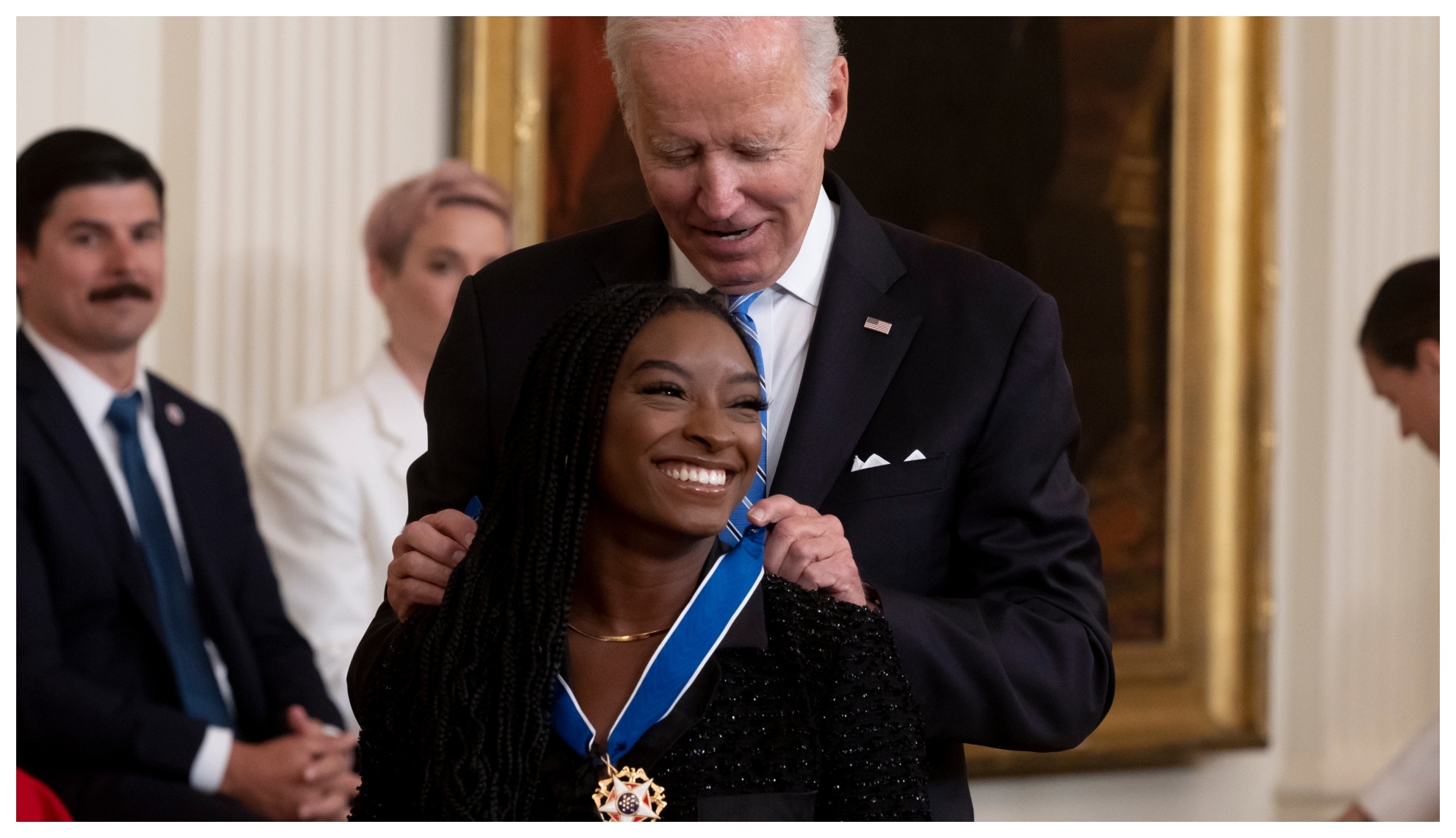 Biles receives her medal from Biden.