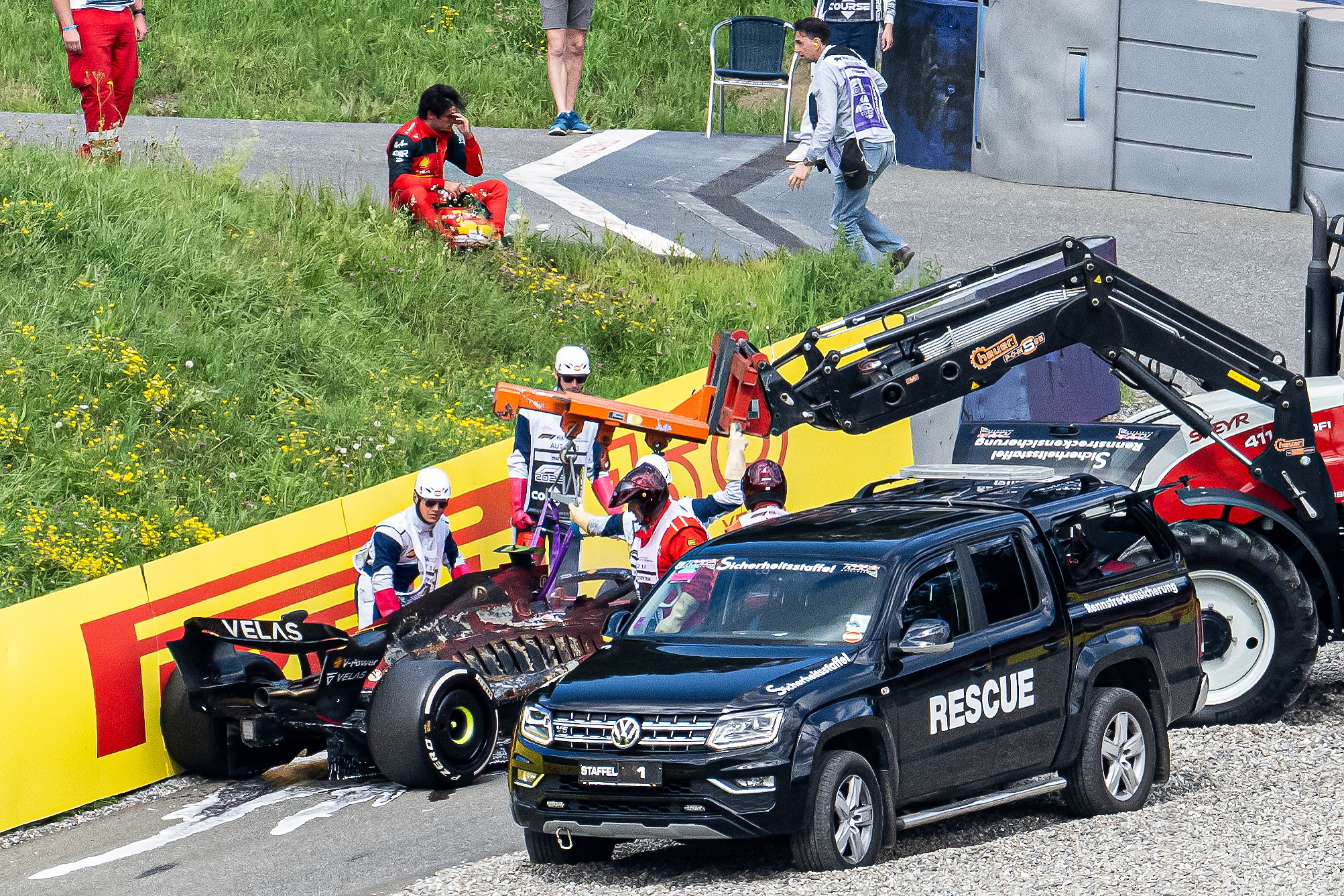 La grúa sacando el coche de Carlos Sainz una vez extinguido el fuego