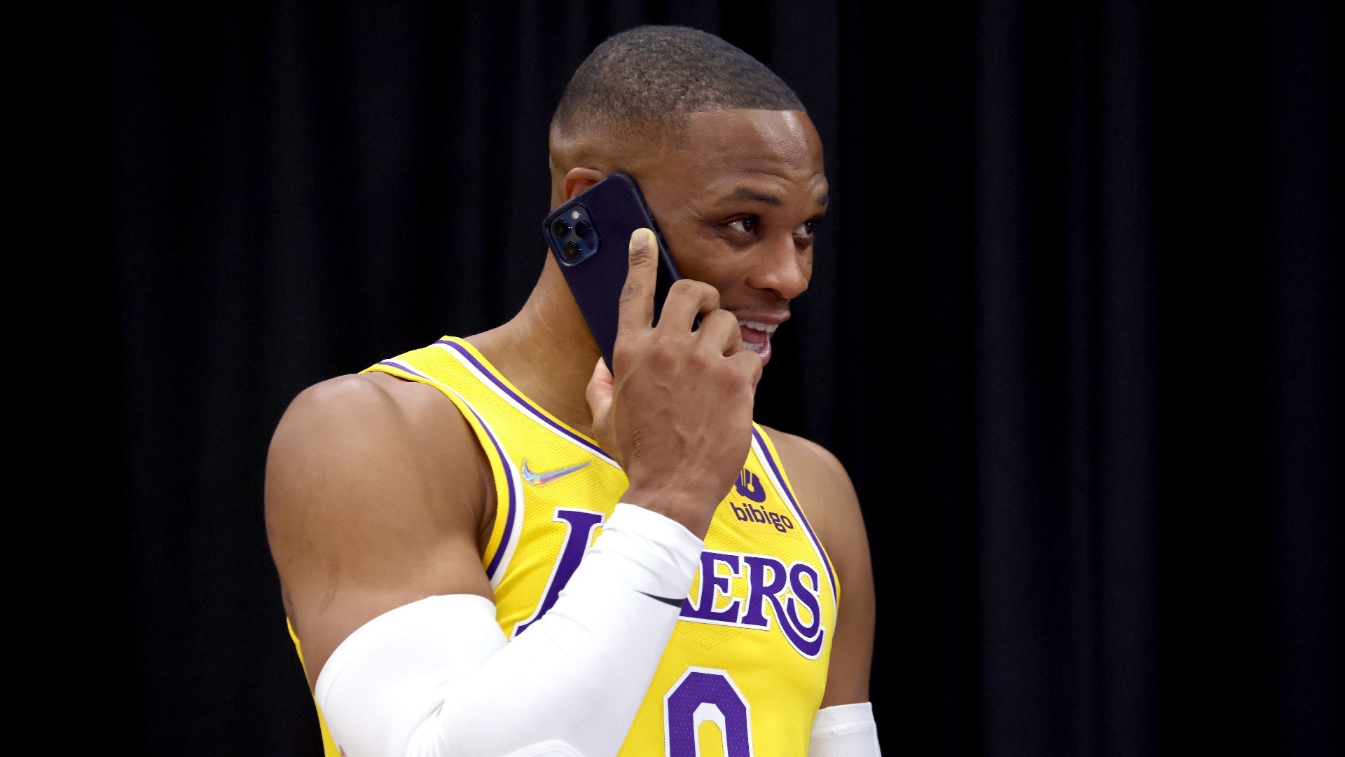 Russell Westbrook habla por teléfono durante una sesión oficial de fotos de los Lakers.