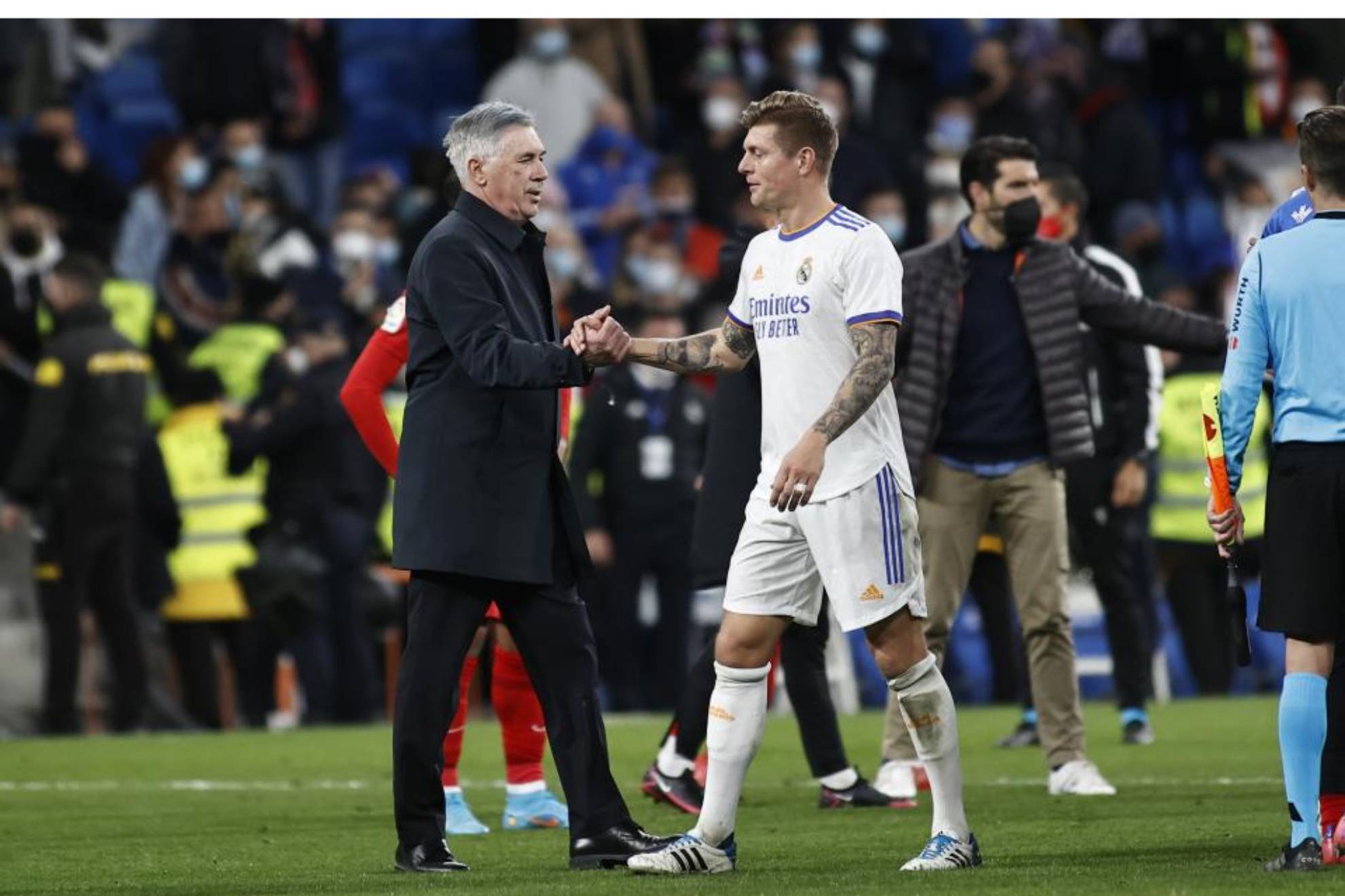 Kroos y Ancelotti se saludan durante un partido.