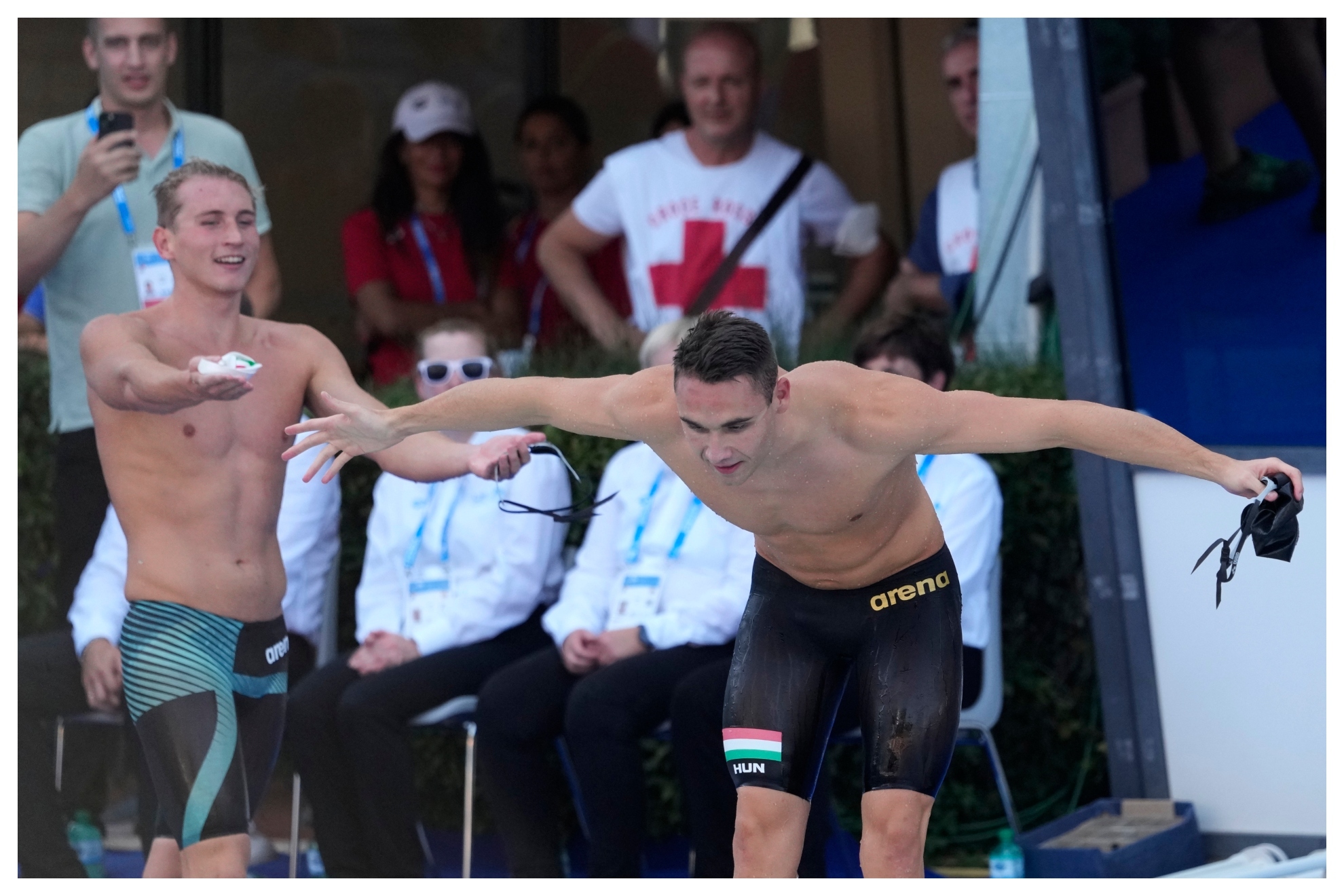 Los húngaros Marton y Milak, mientras el campeón saluda al público. / AP