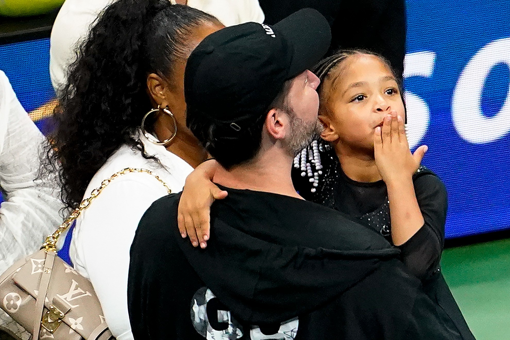 Olympia Ohanian blows a kiss to the crowd while in the arms of her father Alexis Ohanian. / AP