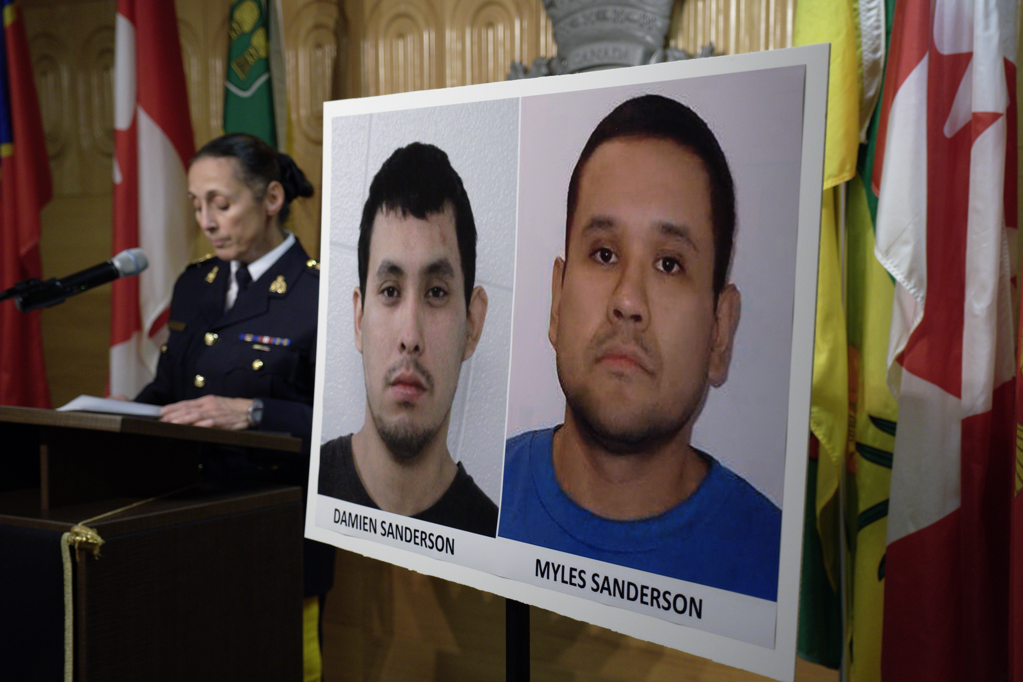 Assistant Commissioner Rhonda Blackmore speaks next to images of Damien Sanderson and Myles Sanderson during a press conference in Saskatchewan. AP