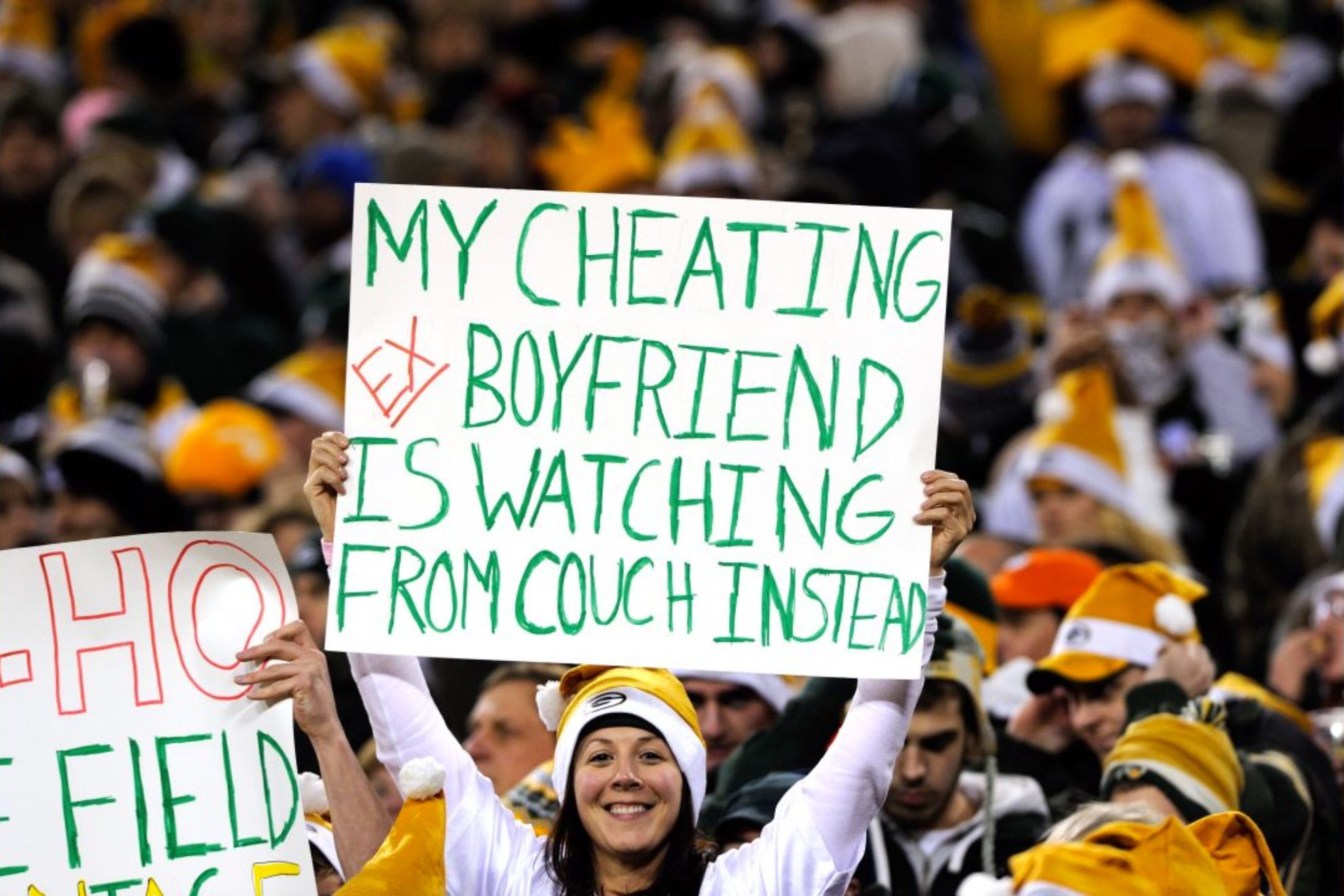 Fan holds sign at a Packers game, getting back at hey ex boyfriend. -AP