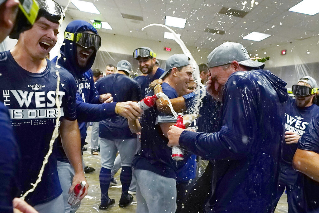 Los Angeles Dodgers celebrate in the locker room after a 4-0 win in a baseball game against the Arizona Diamondbacks in Phoenix, Tuesday, Sept. 13, 2022. The Dodgers clinched the National League West. -AP