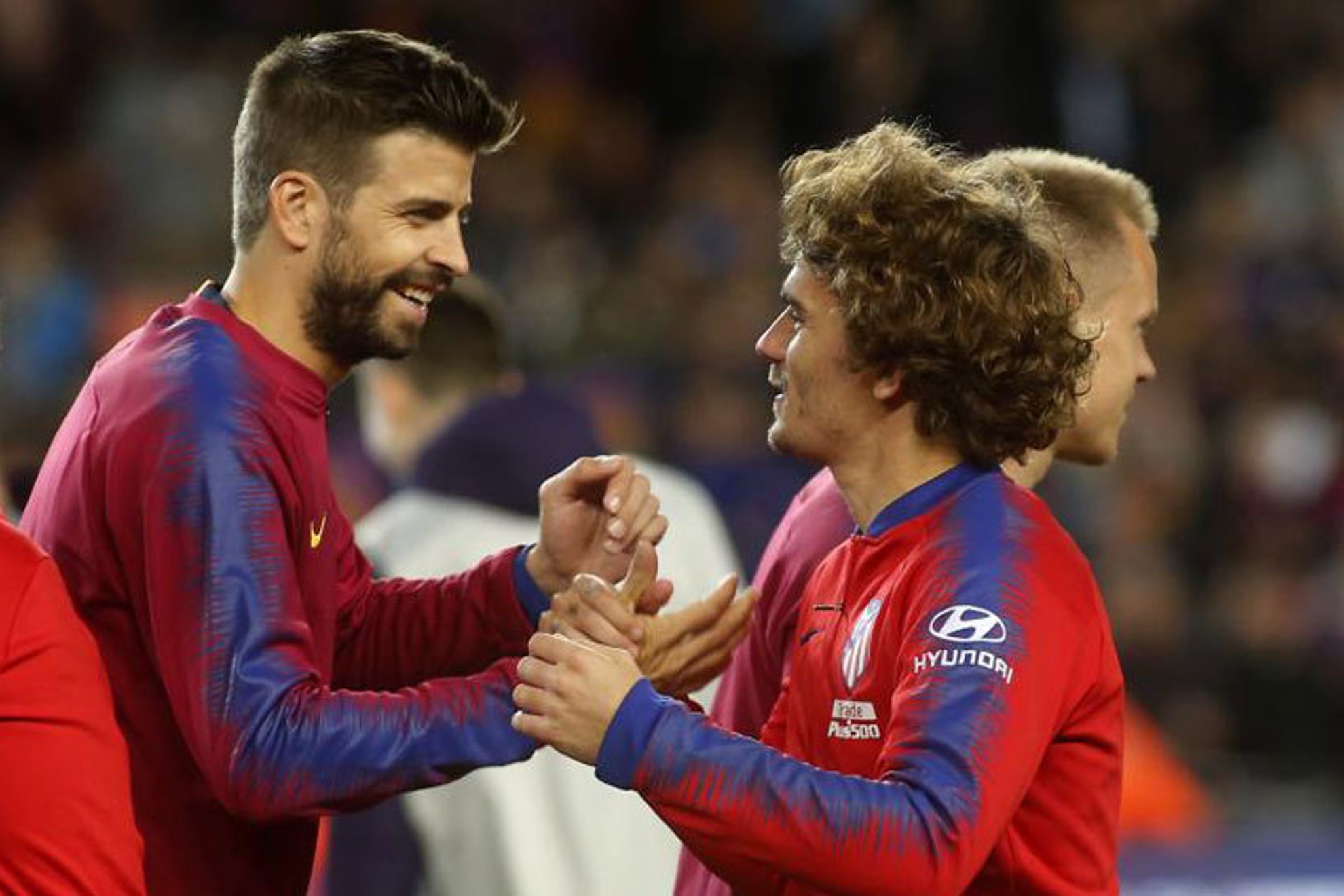 Piqué y Griezmann, socios de Sorare, saludándose en un FC Barcelona - Atlético / FRANCESC ADELANTADO
