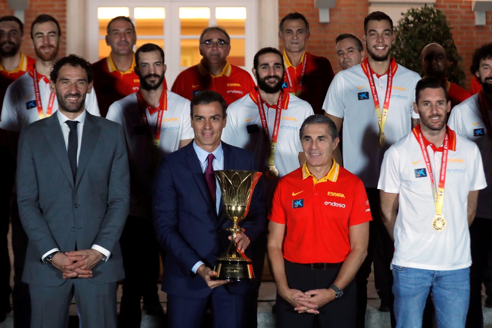 El presidente del Gobierno, Pedro Sánchez, entre Jorge Garbajosa y Sergio Scariolo, con el trofeo del Mundial 2019. EFE