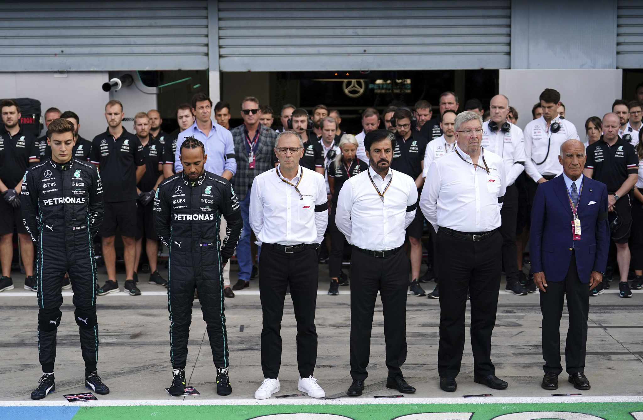 Mercedes George Russell, left, Lewis Hamilton, second left, F1 CEO Stefano lt;HIT gt;Domenicali lt;/HIT gt;, centre left, FIA President Mohammed ben Sulayem, centre right, and Managing Director Ross Brawn, second right, stand during a minutes silence following the death of Queen Elizabeth II on Thursday prior to first practice at the Italian Grand Prix, Monza, Italy, Friday Sept. 9, 2022. (David Davies/PA via AP)