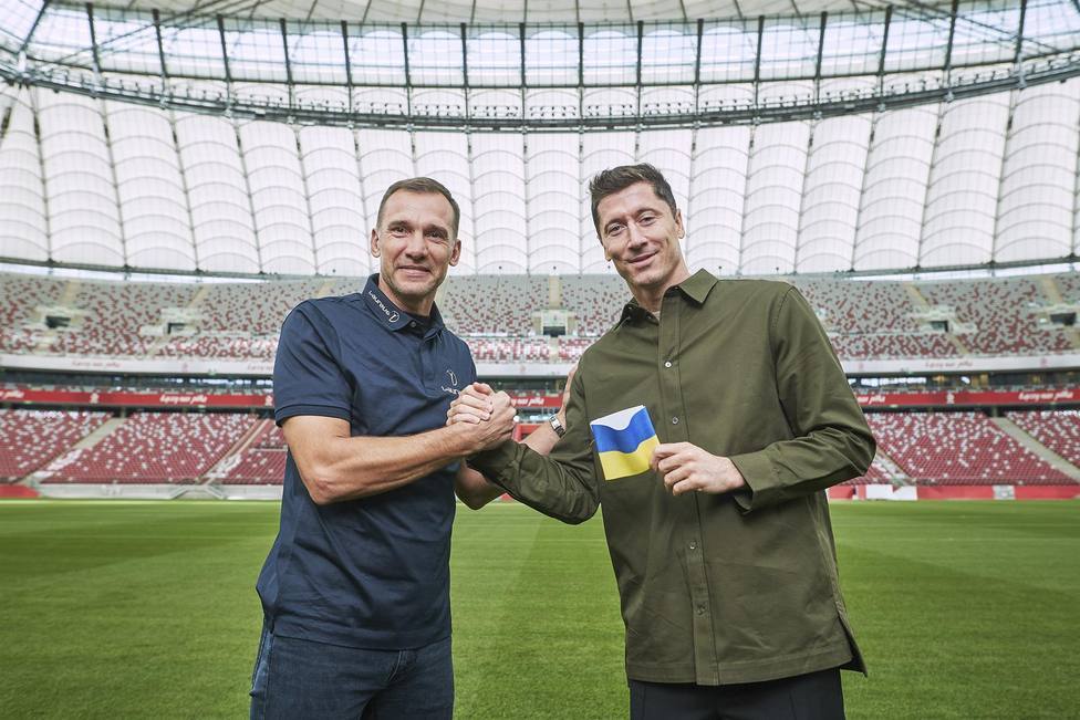 Andriy Shevchenko y Robert Lewandowski enseñan el brazalete con los colores ucranianos en el Estadio Nacional de Varsovia. / EFE