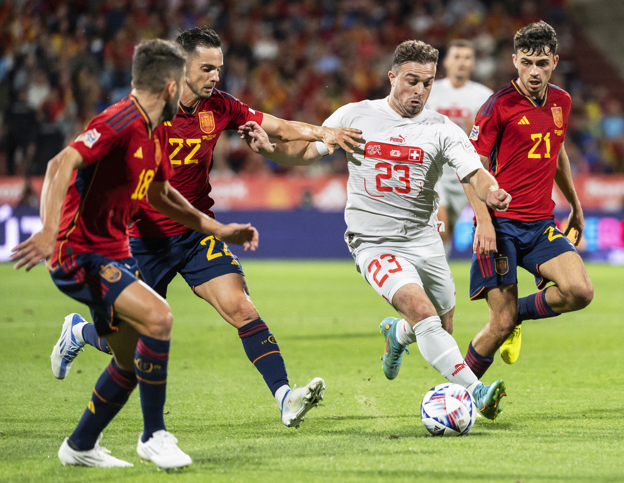 Switzerland's Xherdan Shaqiri in action against Spanish players (L-R) Jordi Alba, Pablo Sarabia, and Pedri