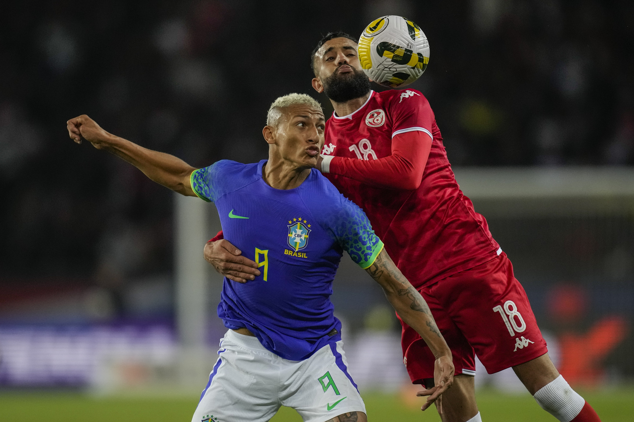 Tunisias Ghaylen Chaaleli, right, duels for the ball with Brazils Richarlison 