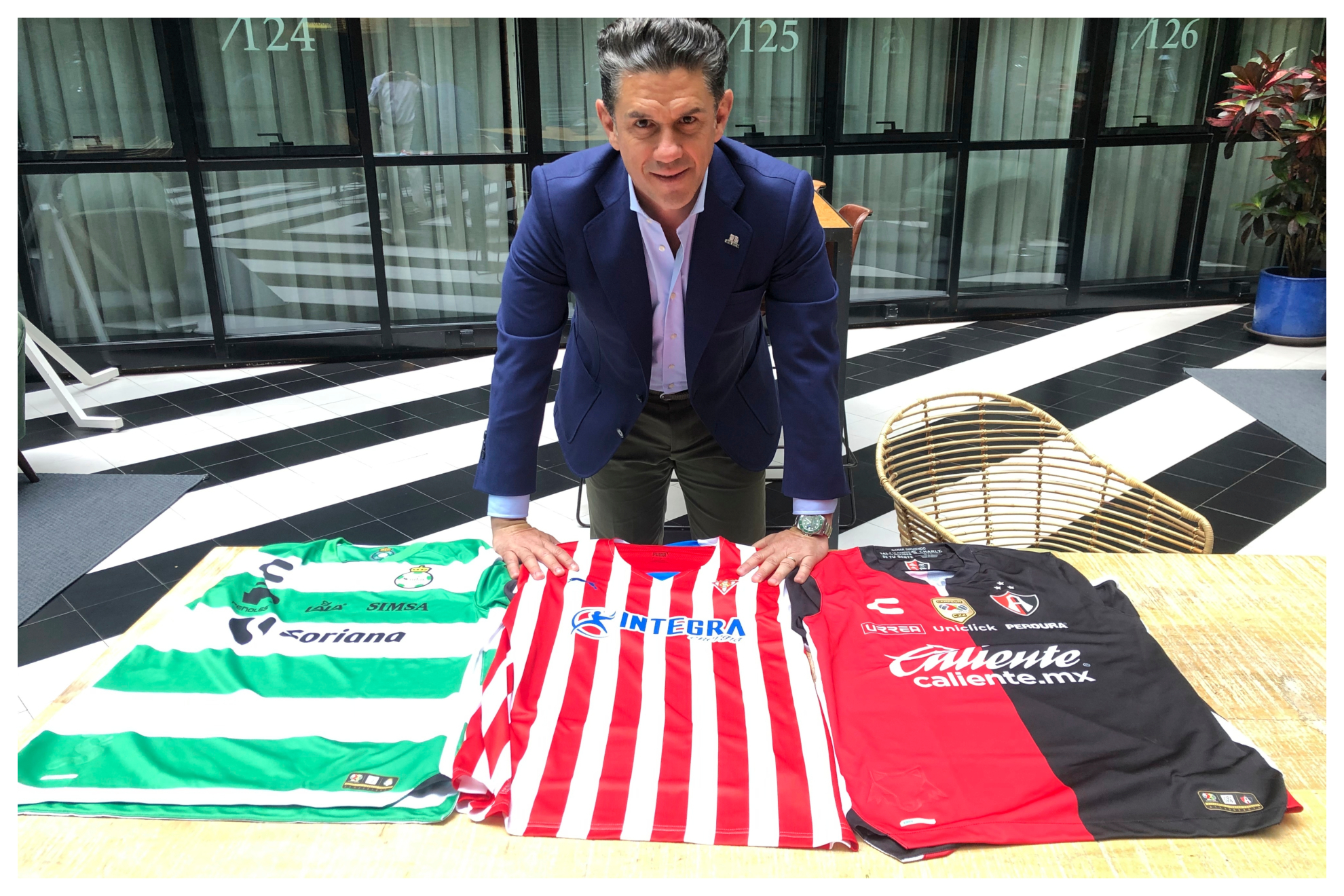 Irarragorri, presidente del Grupo Orlegi, junto a las camisetas de los tres cubes del Grupo: Santos, Sporting y Atlas. JUAN CASTRO