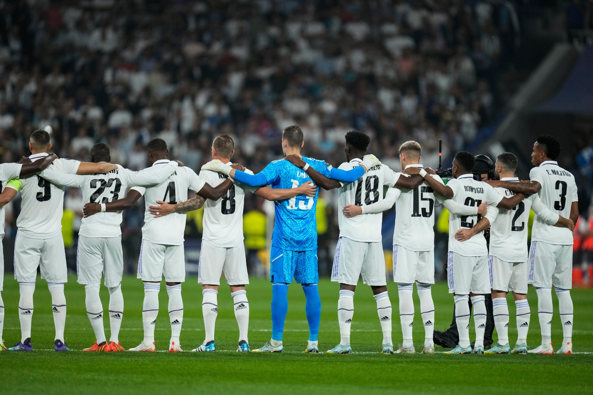 Los jugadores del Madrid, abrazados durante el minuto de silencio que se guardó antes del partido. AP