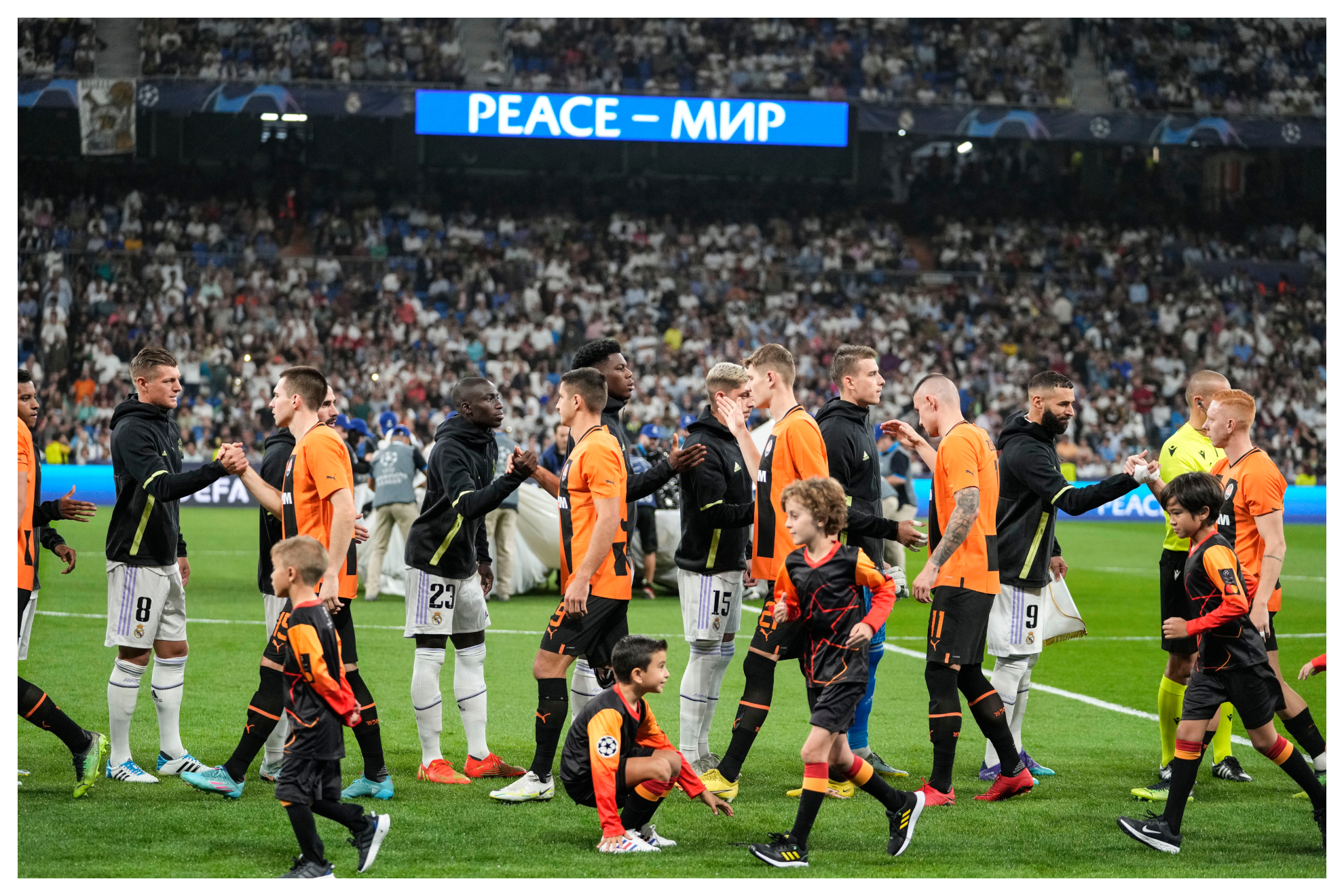 Los jugadores de Real Madrid y Shakhtar, con el mensaje de paz al fondo/CHEM REY