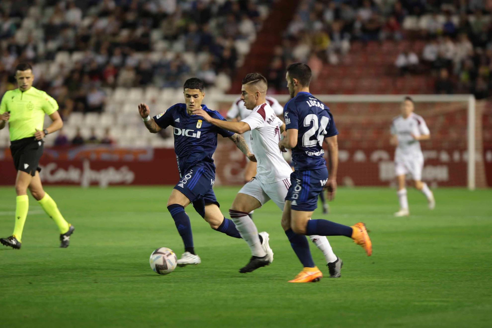 Manuel Fuster conduce el balón entre dos jugadores del Oviedo / JOSE SANCHEZ