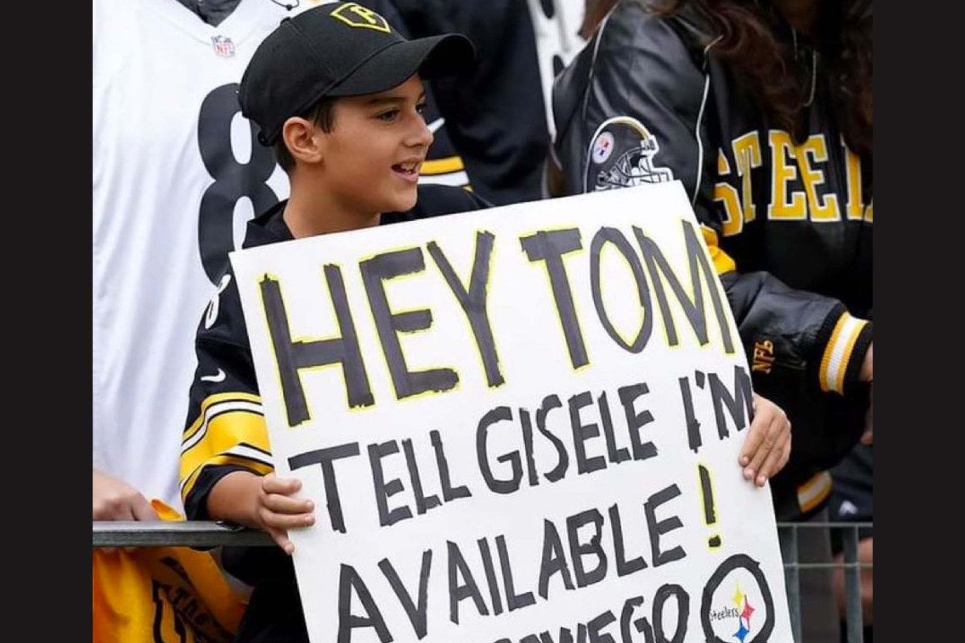 Child at Bucs vs Steelers game holds sign saying "Hey Tom, tell Gisele I'm available!" -S.G.