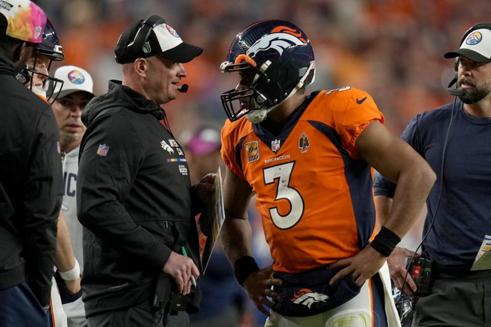 Russell Wilson talking to Broncos head coach Nathaniel Hackett during a game.