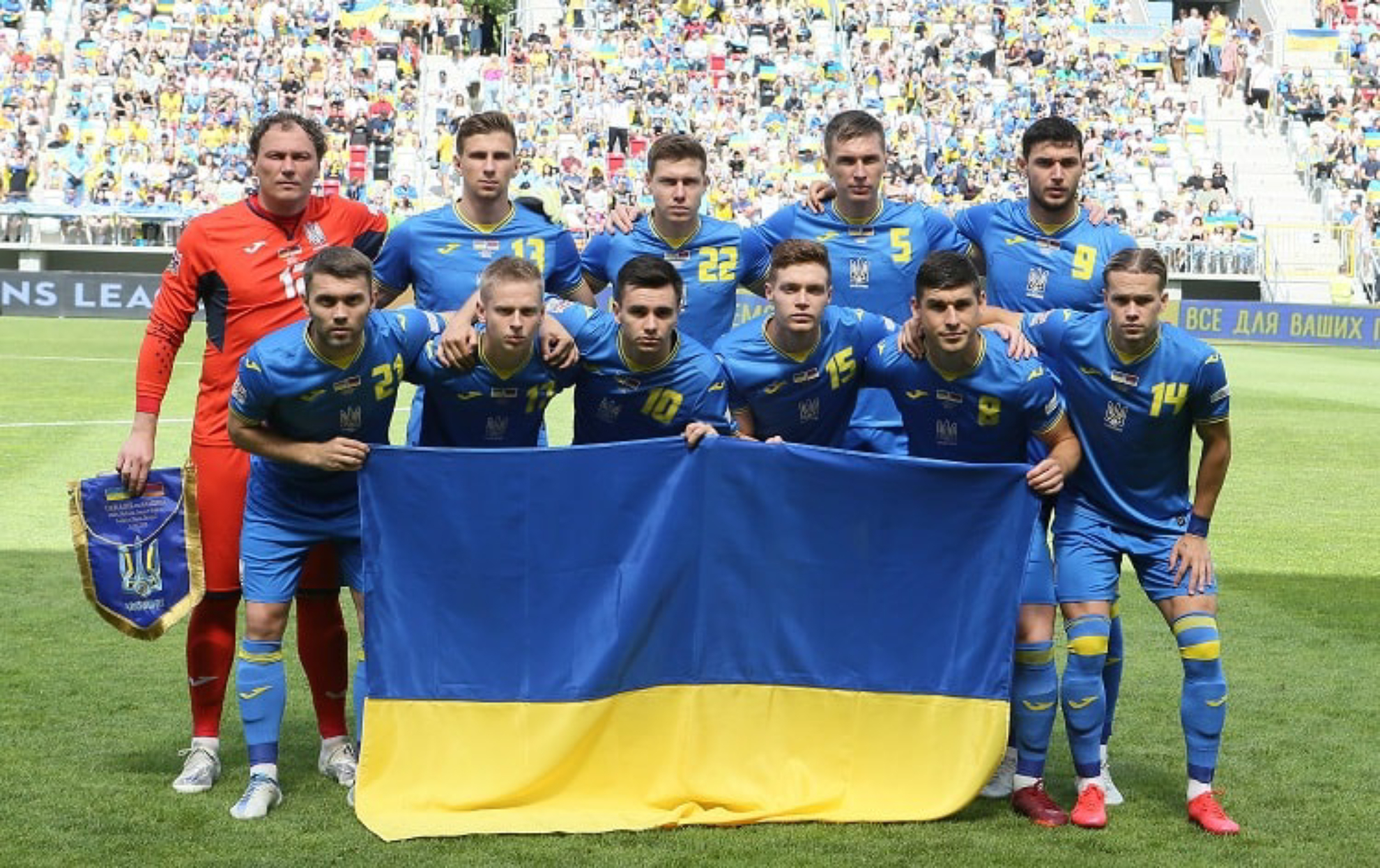 La selección de Ucrania posa con la bandera durante un partido.