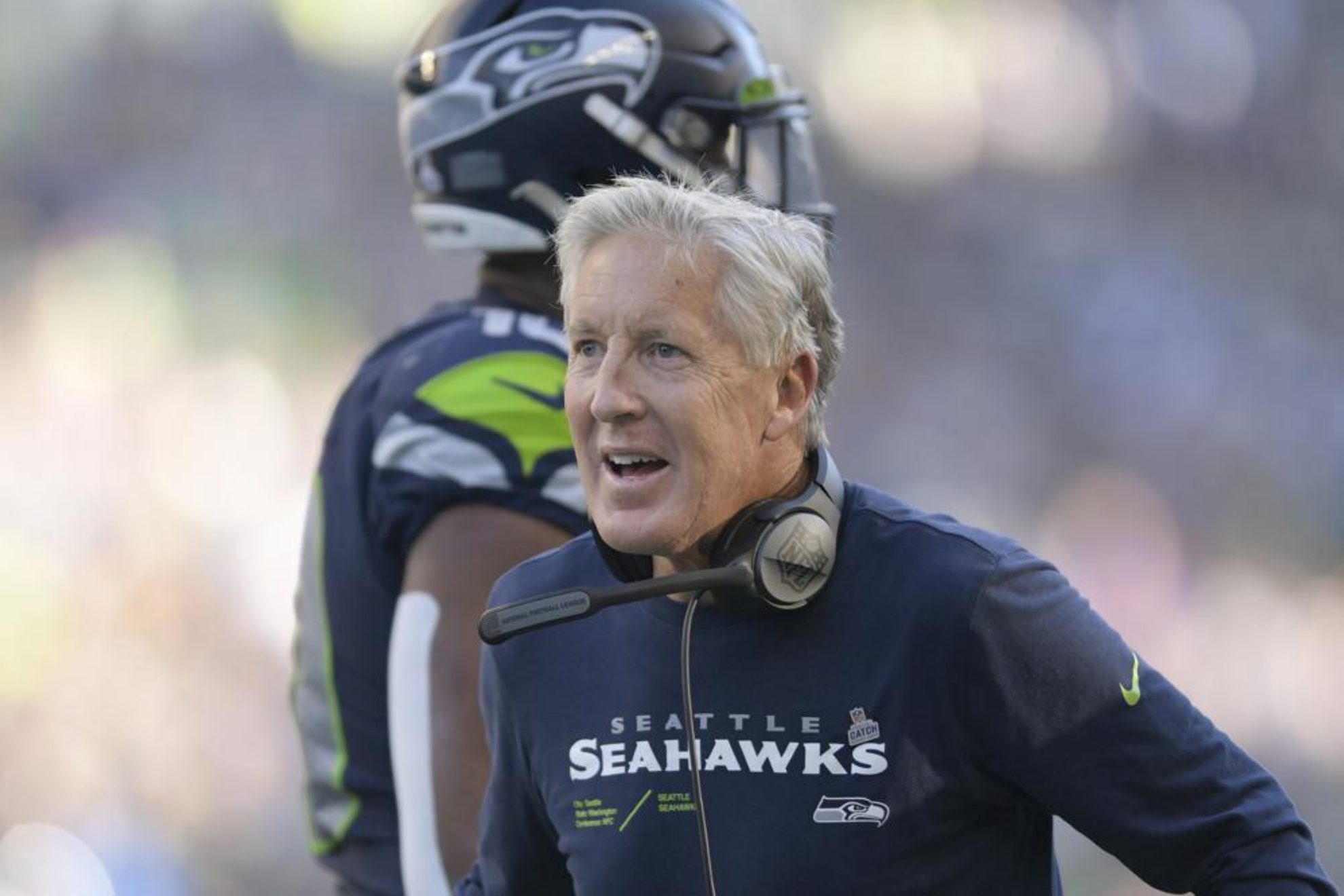 Seattle Seahawks head coach Pete Carroll greets players during an NFL game.