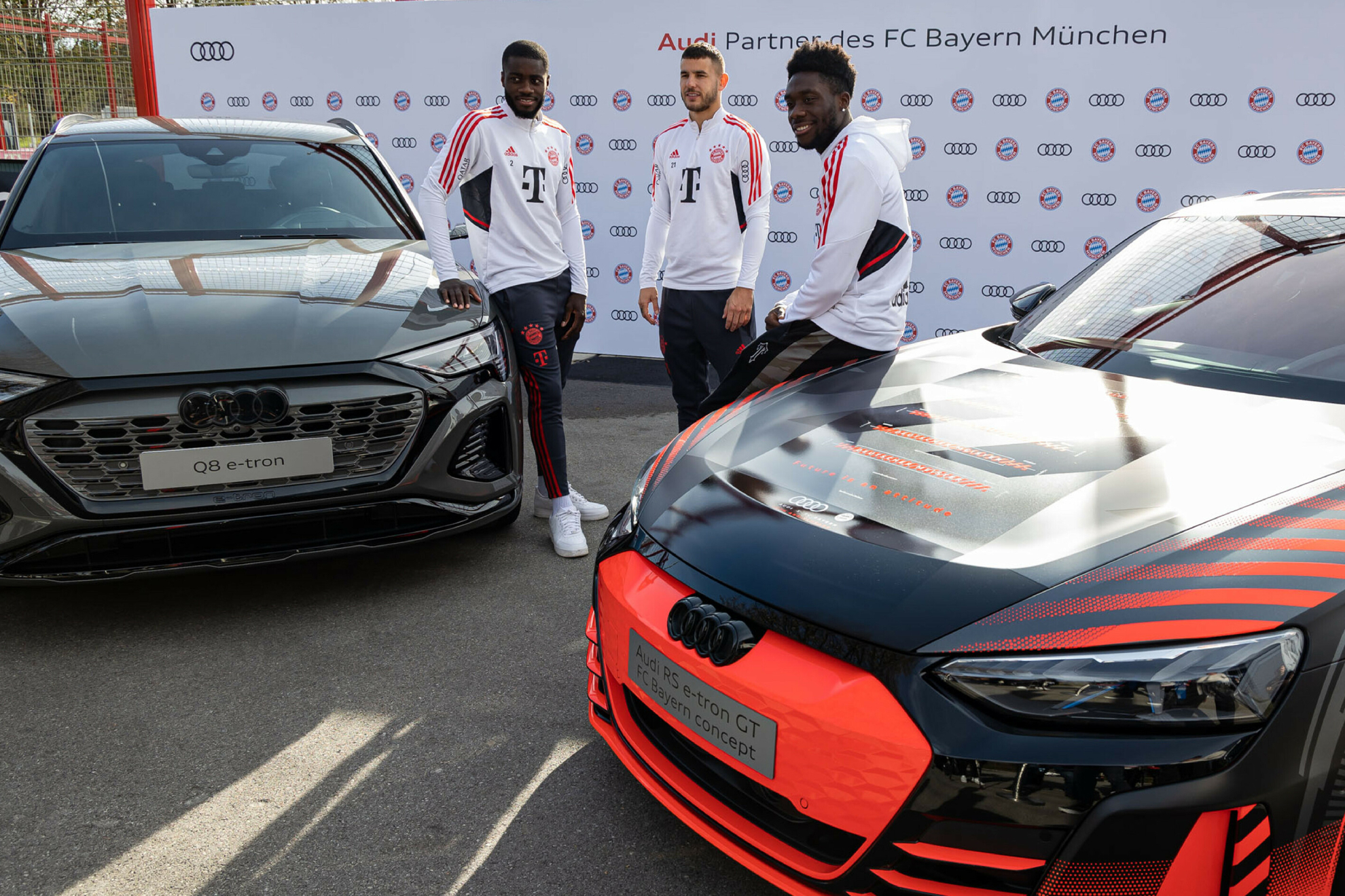 Los jugadores, posando ante los coches traídos por los trabajadores de Audi.