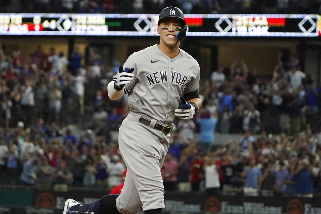 New York Yankees' Aaron Judge gestures as he runs the bases after hitting a solo home run, his 62nd of the season, during the first inning in the second baseball game of a doubleheader against the Texas Rangers.