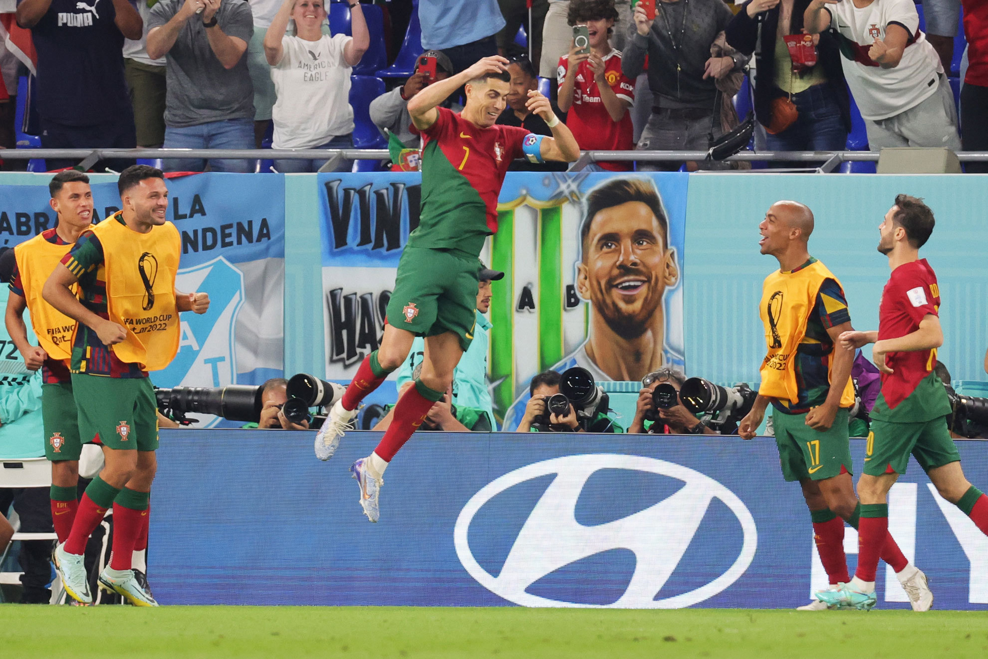 Cristiano celebra su gol con una imagen de Messi de fondo. EFE