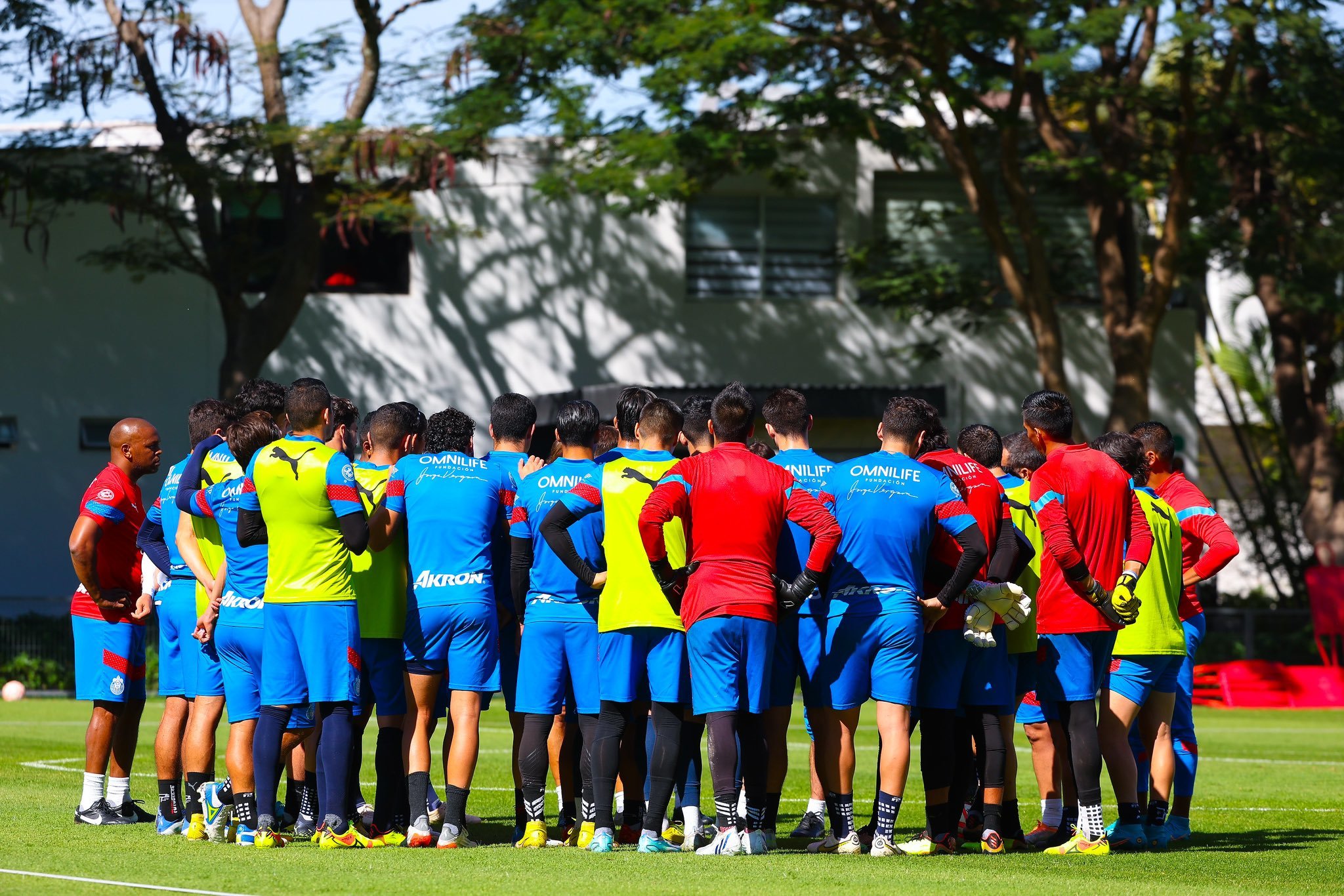 Los jugadores de Chivas atienden las indicaciones de su entrenador durante un entrenamiento.