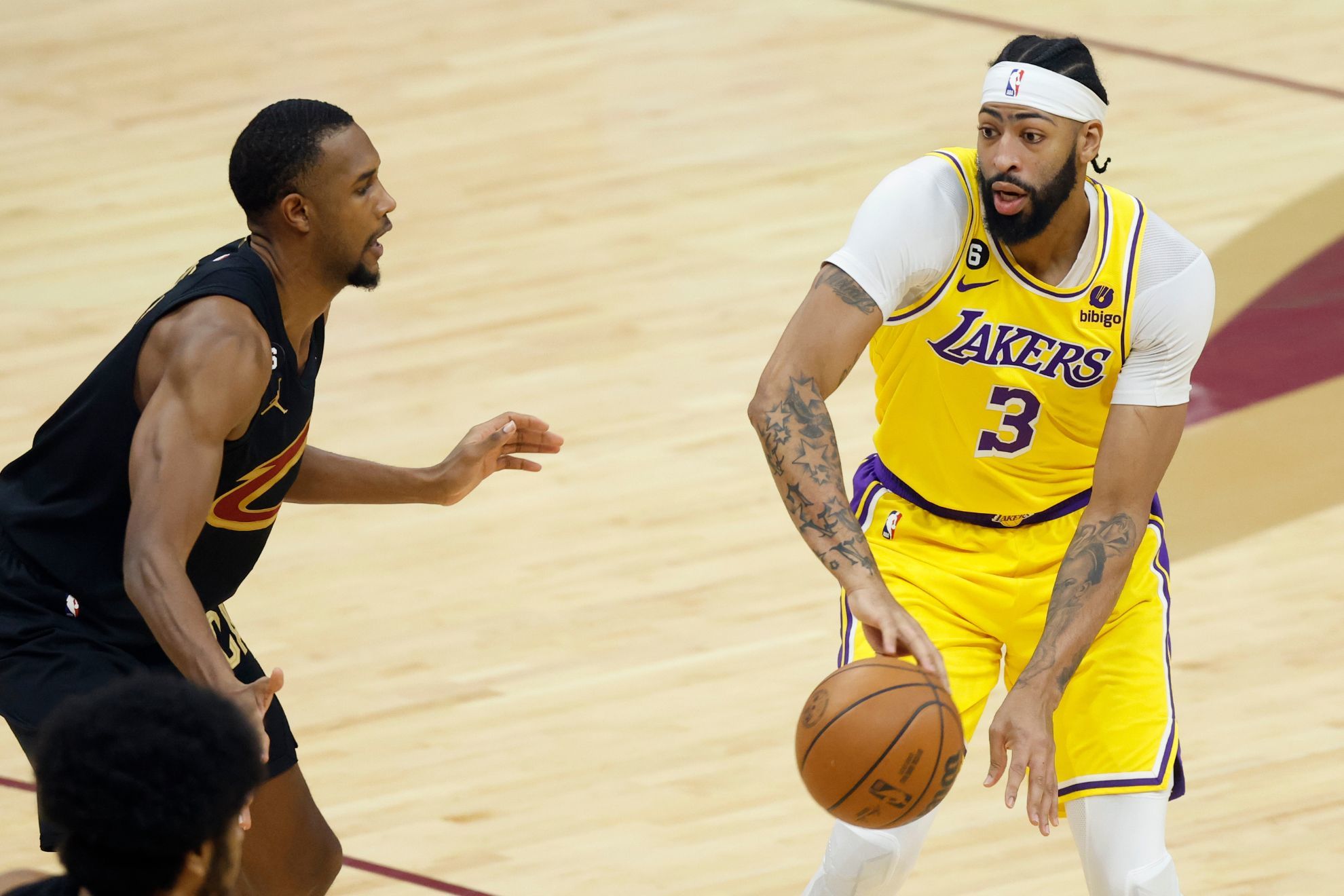 Los Angeles Lakers forward Anthony Davis (3) passes the ball past Cleveland Cavaliers forward Evan Mobley during the first half of an NBA basketball game, Tuesday, Dec. 6, 2022, in Cleveland.