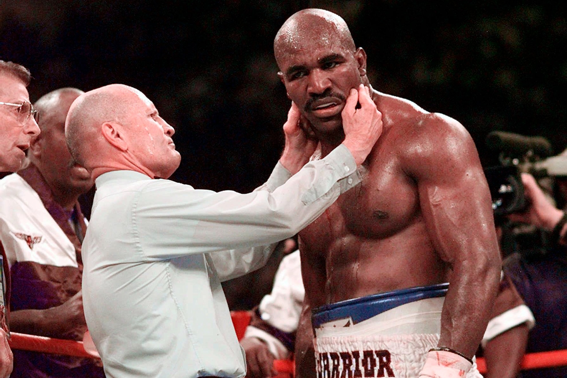 Evander Holyfield has his right ear checked by referee Mills Lane after he was bit on the ear by Mike Tyson.