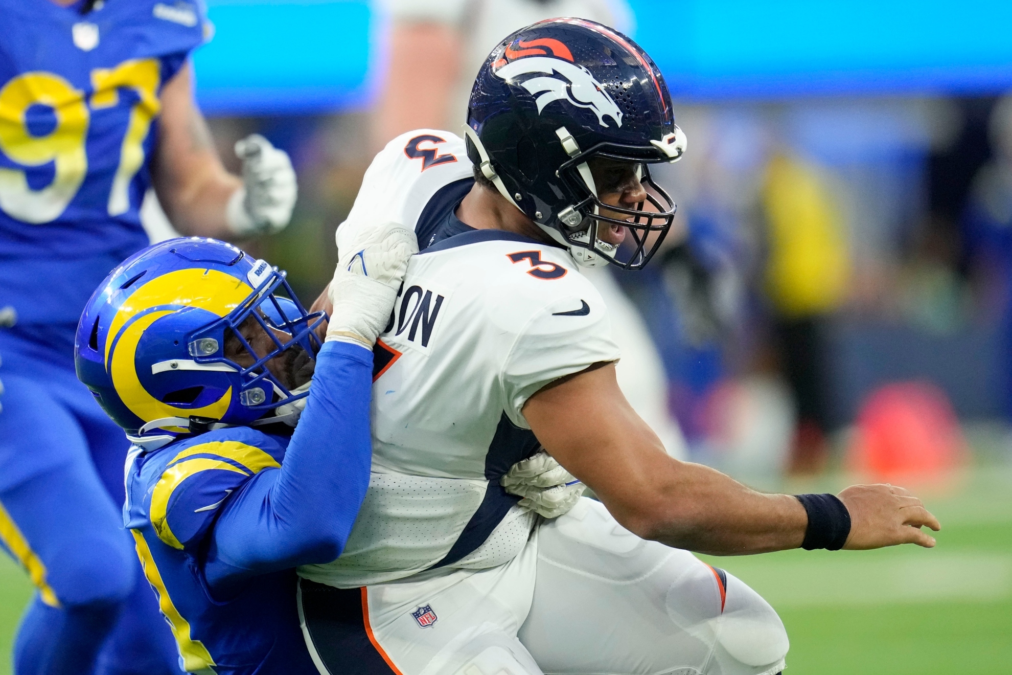 Denver Broncos quarterback Russell Wilson is tackled by Los Angeles Rams linebacker Leonard Floyd