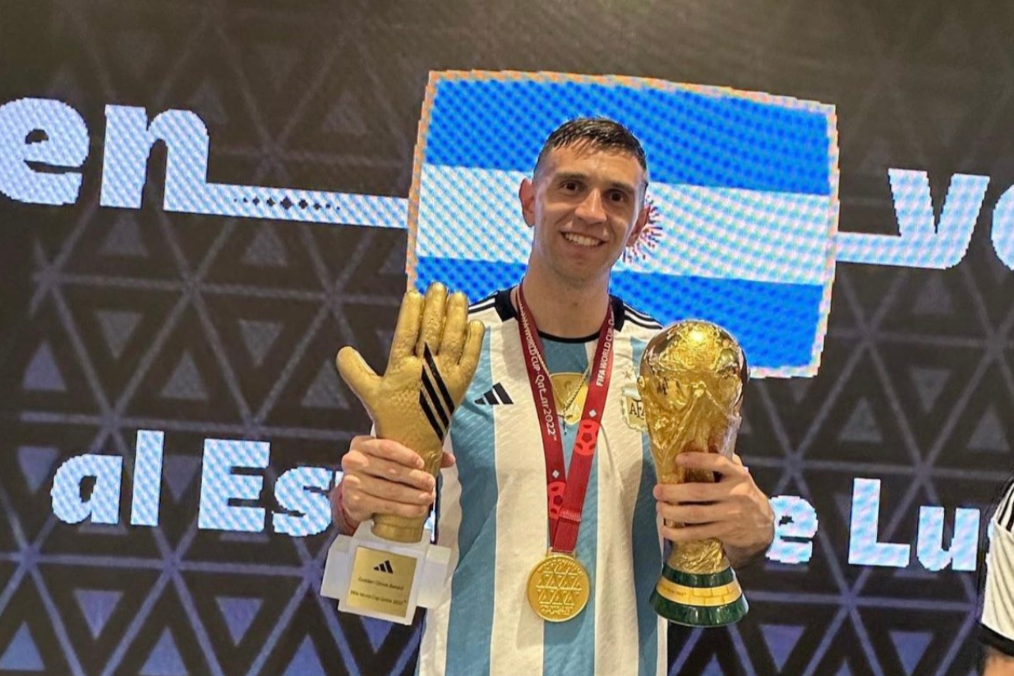 Emiliano Martnez posa con el Mundial, la medalla de campen y el Guante de Oro.