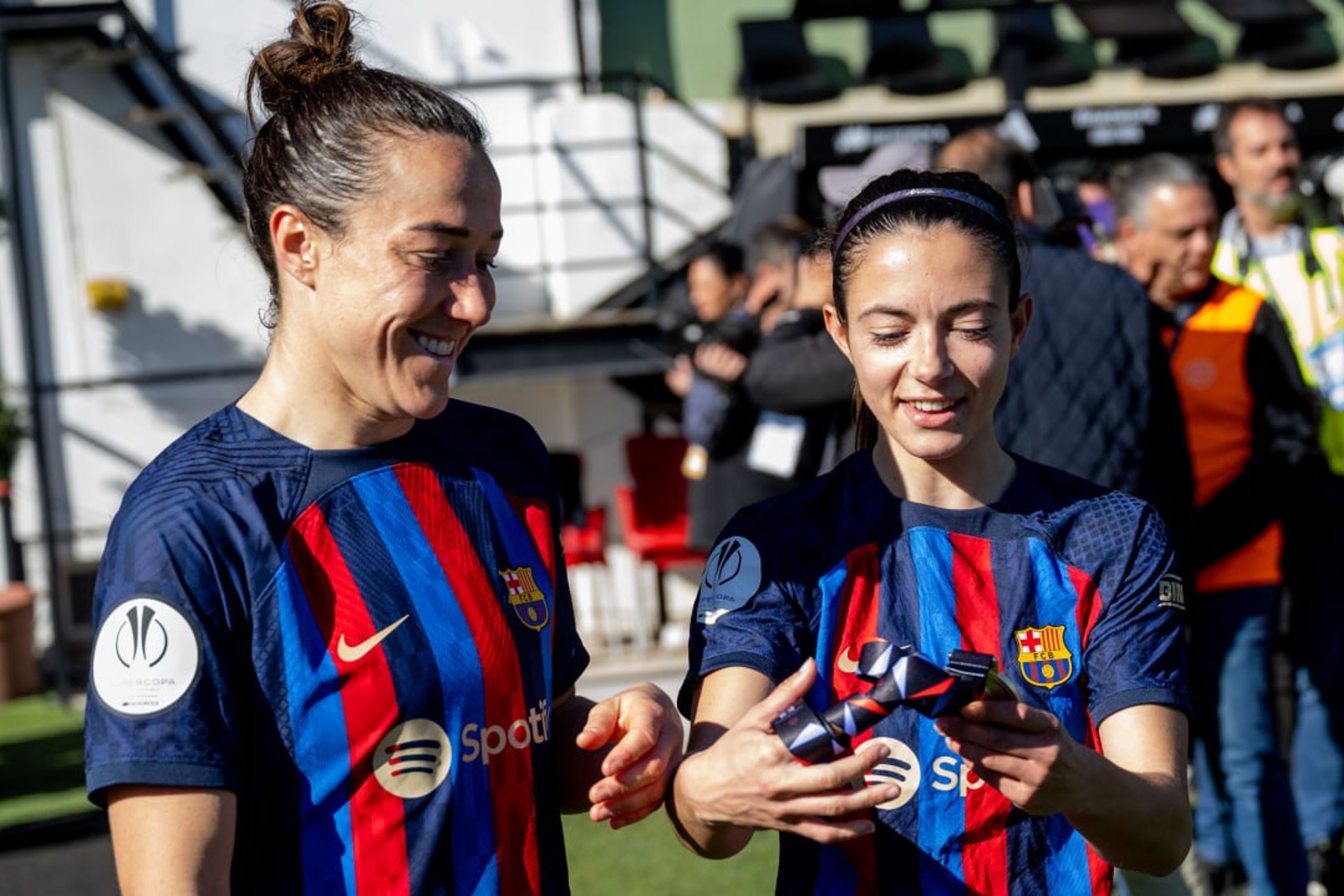 Lucy Bronze y Aitana Bonmatí mirando la medalla de campeonas / FCB
