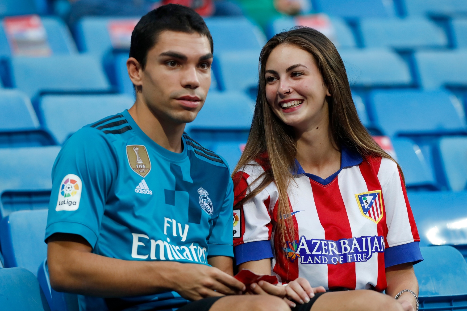Un aficionado del Real Madrid y una hincha del Atlético, juntos en la grada.