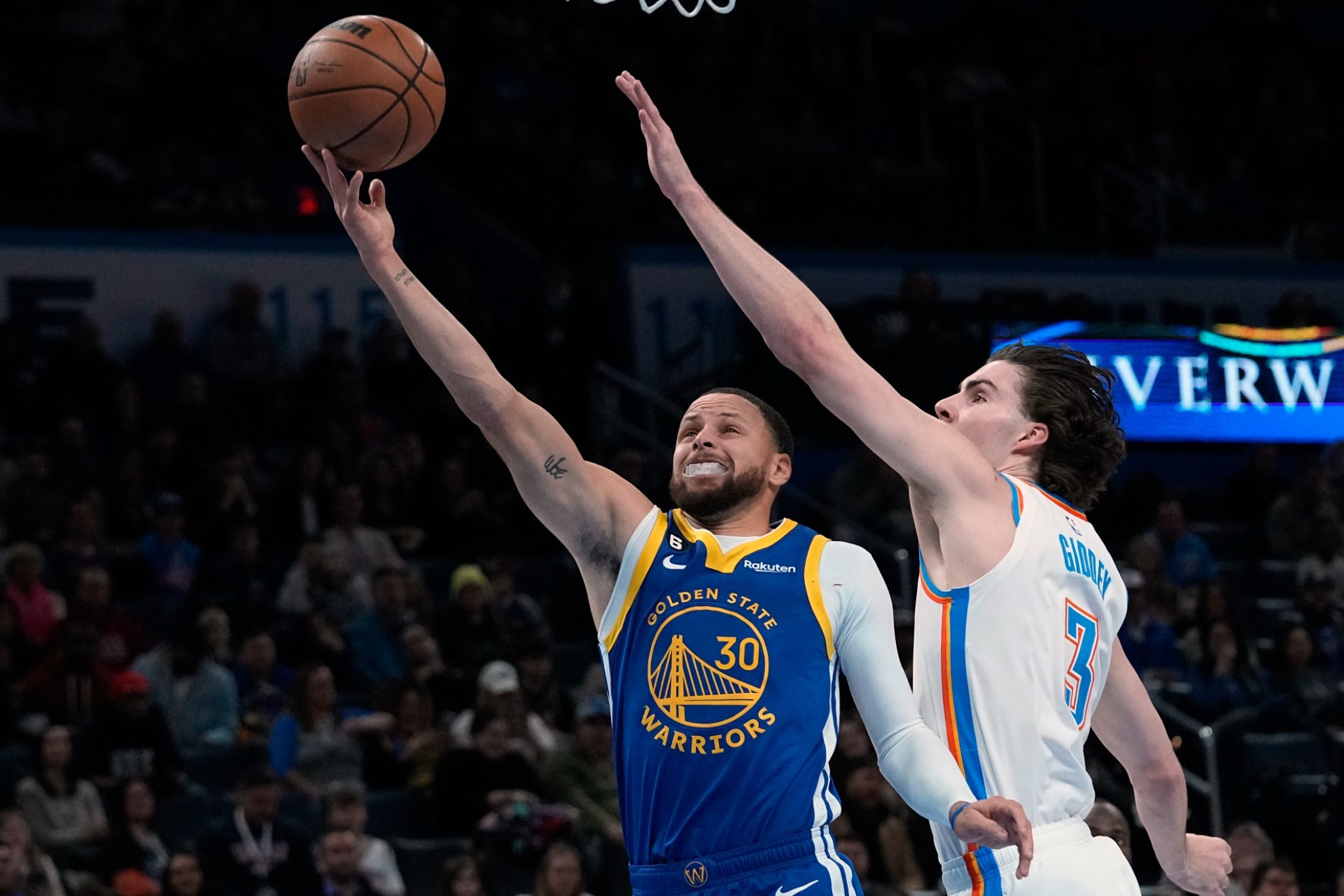 Warriors guard Stephen Curry (30) shoots in front of Oklahoma City Thunder guard Josh Giddey.