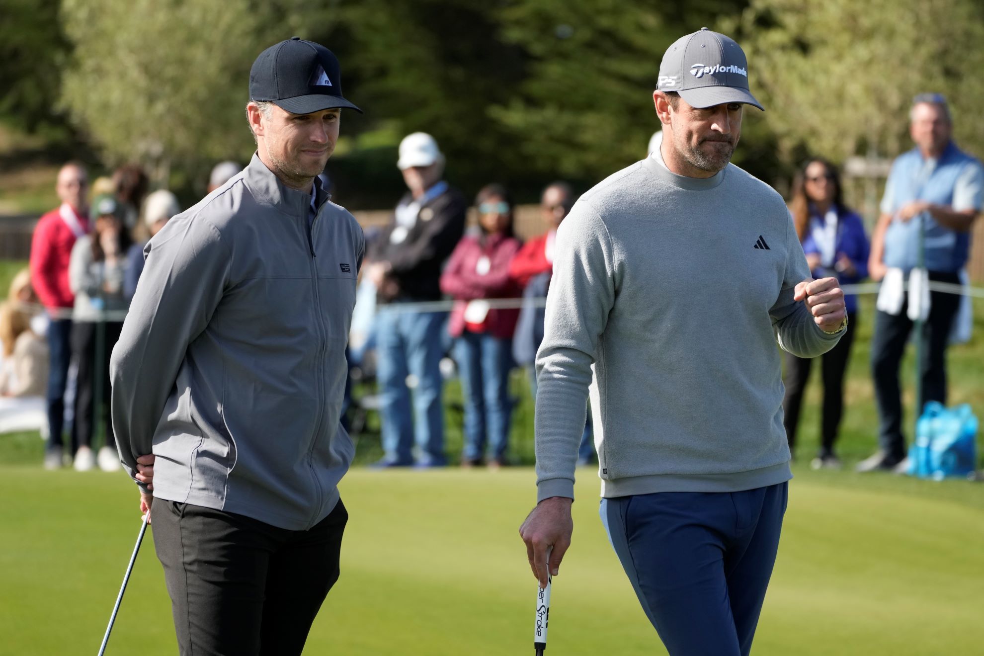 Buster Posey, left, and Aaron Rodgers watch during the putting challenge event of the AT&T Pebble Beach Pro-Am golf tournament in Pebble Beach.