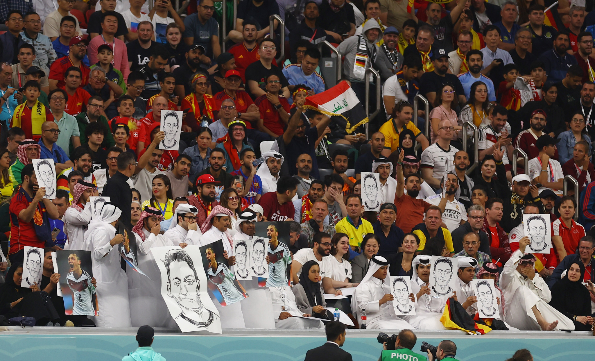 Aficionados qataríes sujetan fotos de Özil durante el Mundial.
