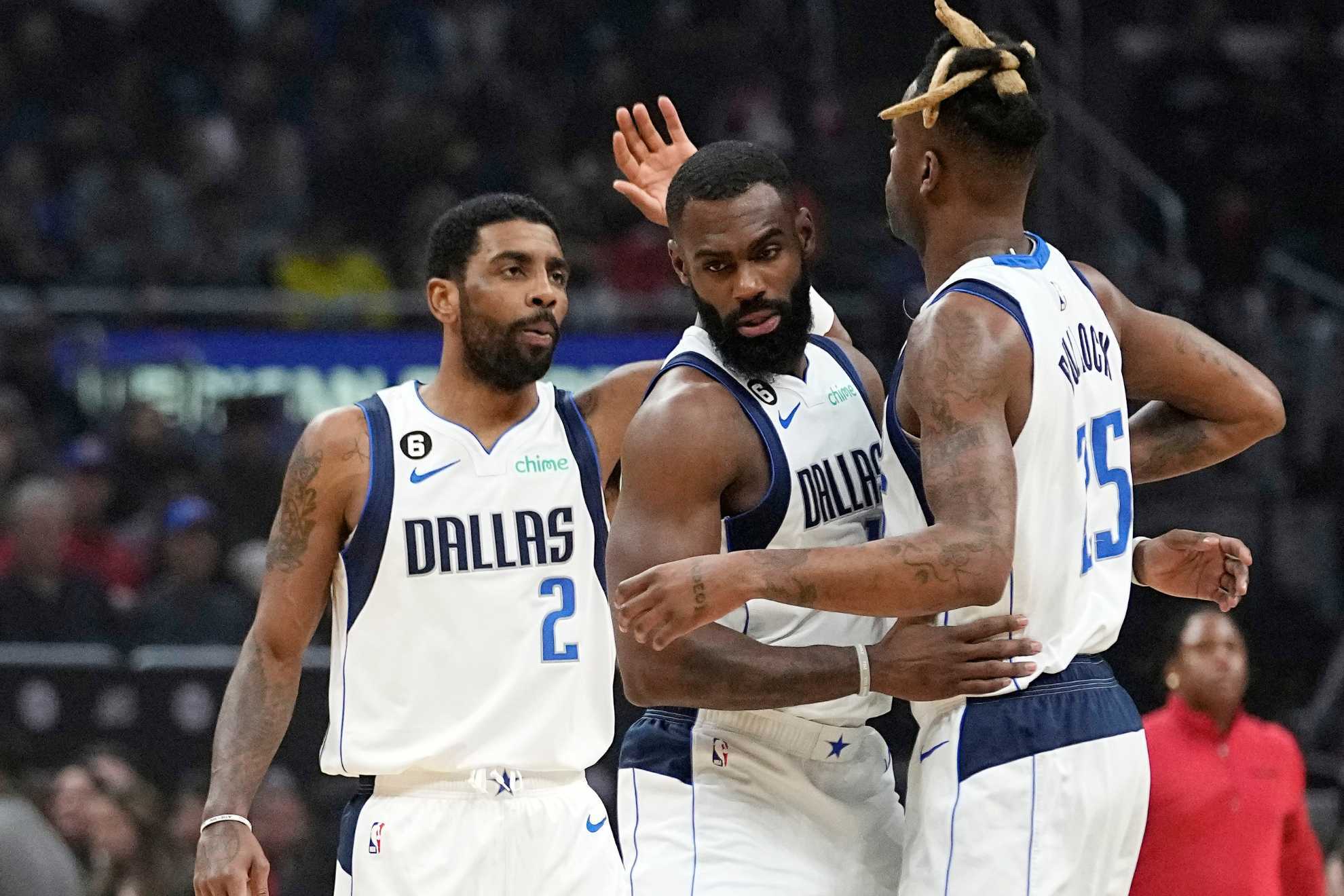 Kyrie Irving, left, celebrates with teammates forward Tim Hardaway Jr., center, and forward Reggie Bullock during the Mavs win over the Clippers.