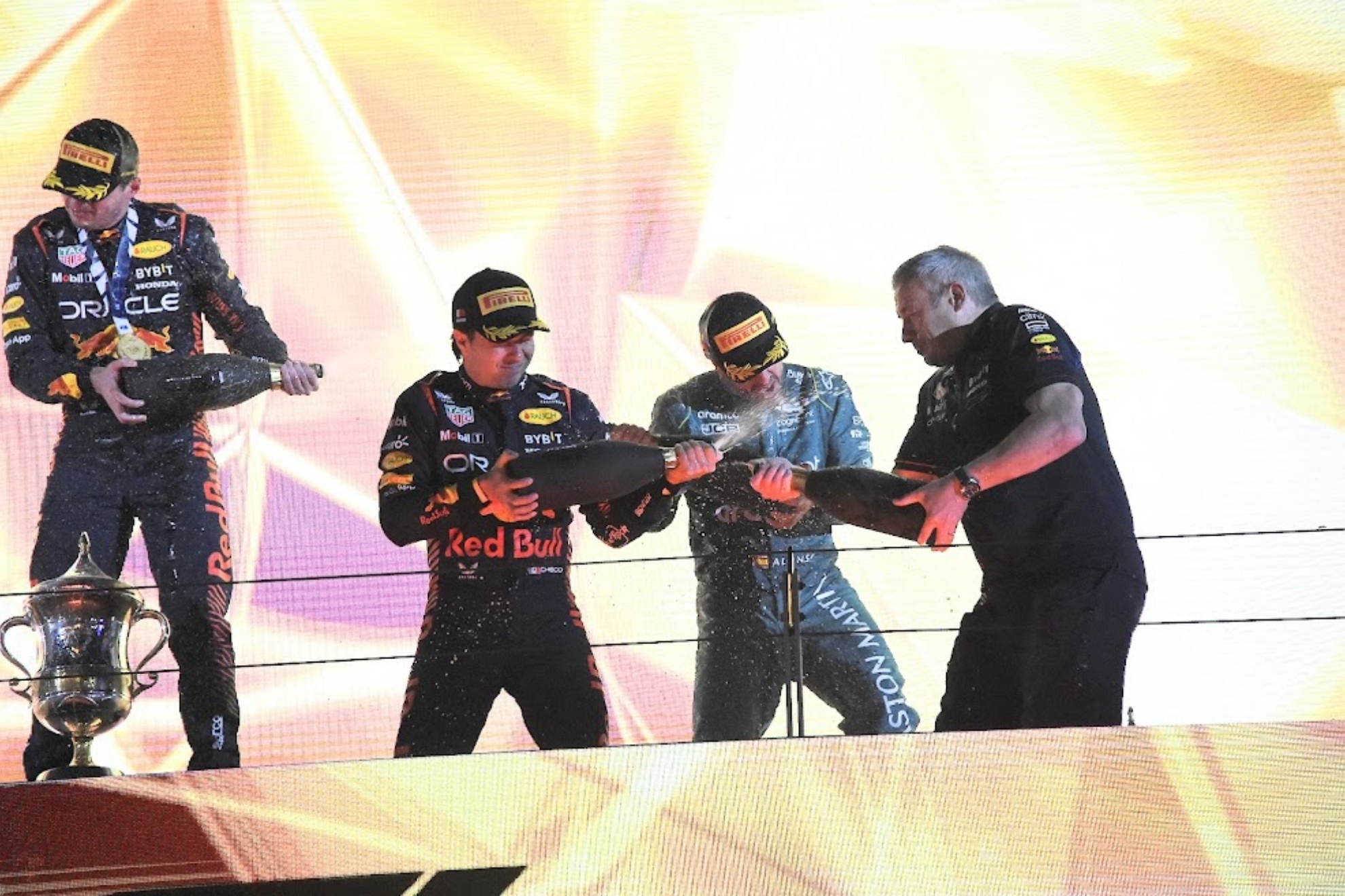Alonso, en el podio de Bahréin rodeado de la gente de Red Bull.