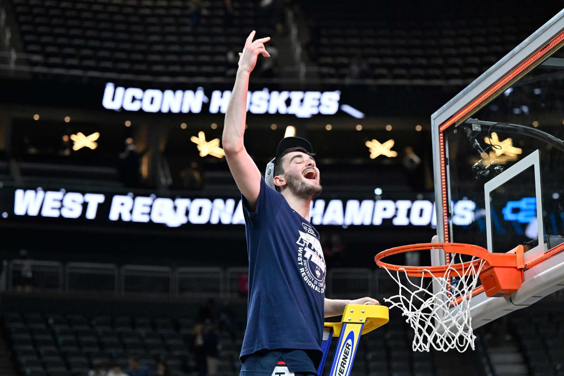 UConn's Alex Karaban celebrates while cutting down the netting from the 82-54 win against Gonzaga.