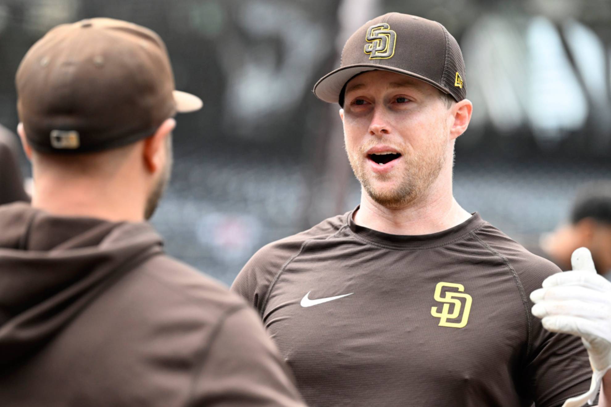 San Diego Padres first baseman Jake Cronenworth, right, talks with a teammate
