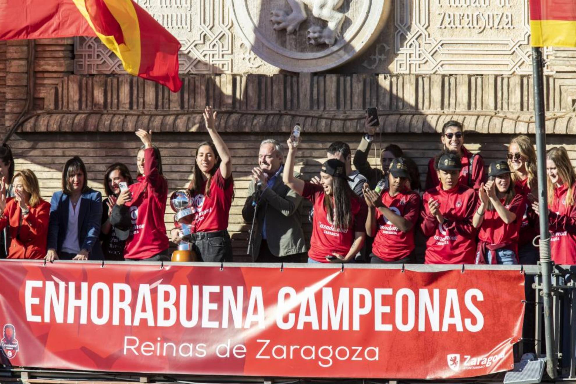 Las jugadoras del Casademont Zaragoza saludan desde el balcón del Ayuntamiento.