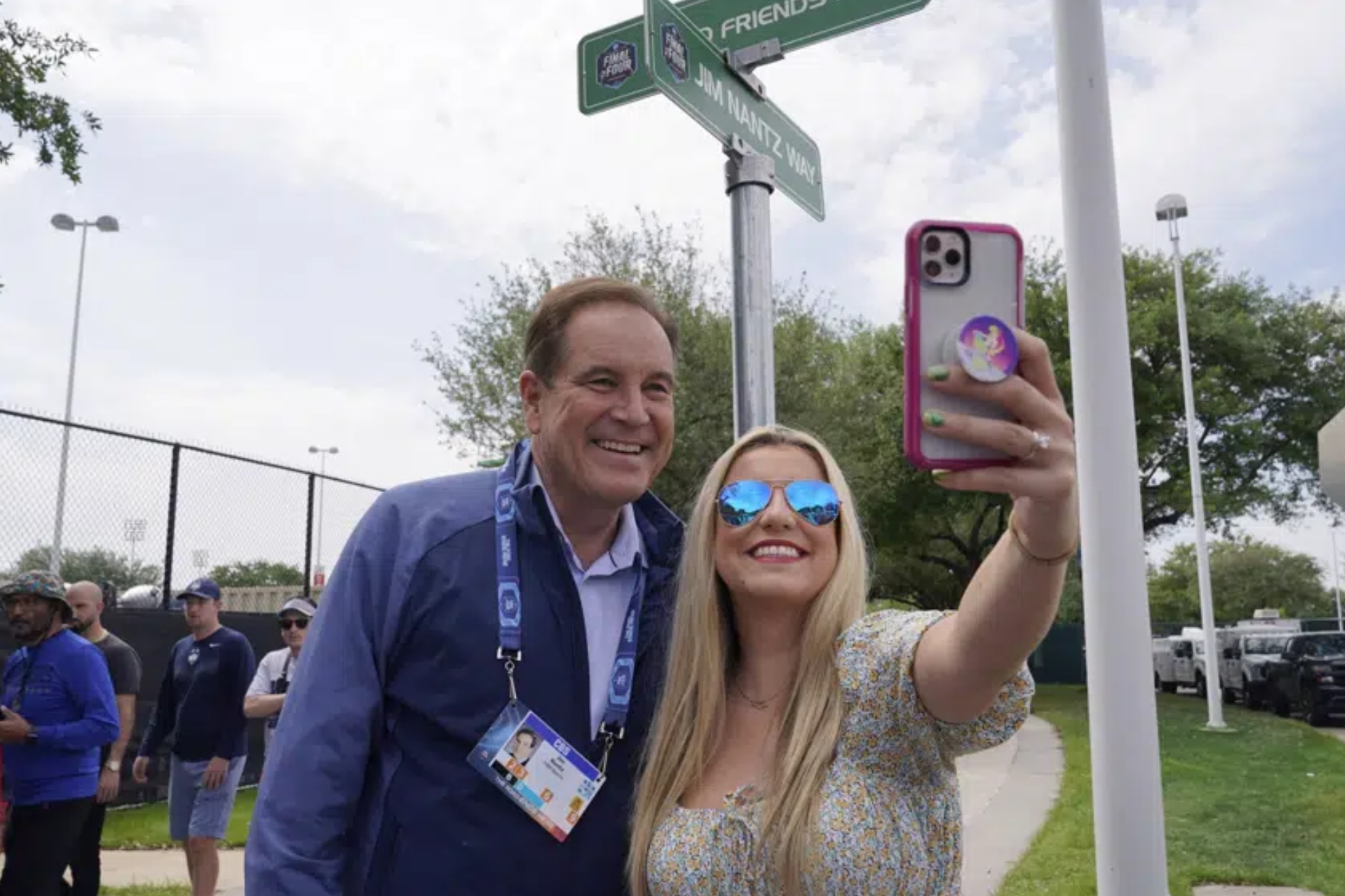 Jim Nantz taking a picture with a fan at March Madness.