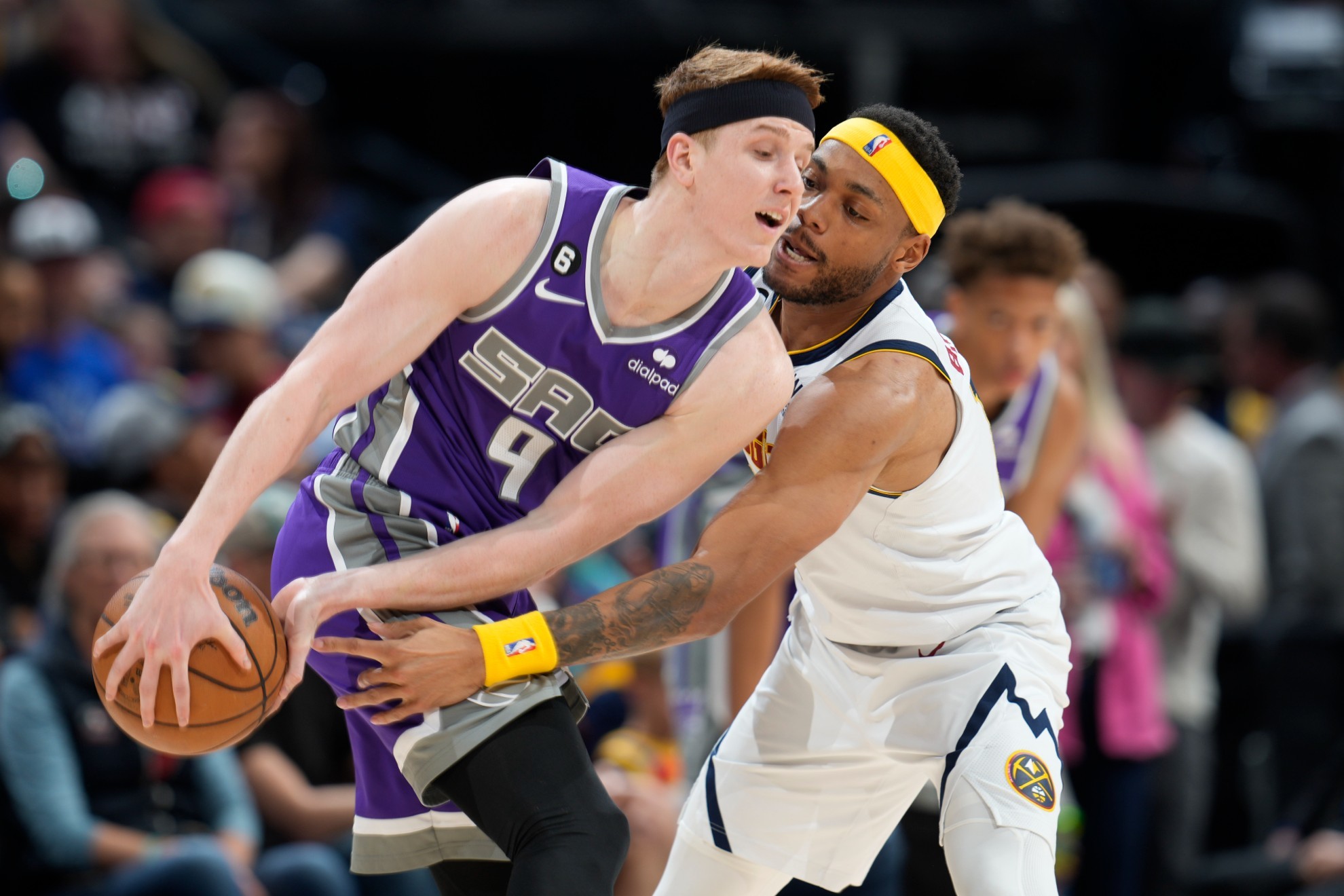 Sacramento Kings guard Kevin Huerter, left, protects the ball as Denver Nuggets forward Bruce Brown defends.